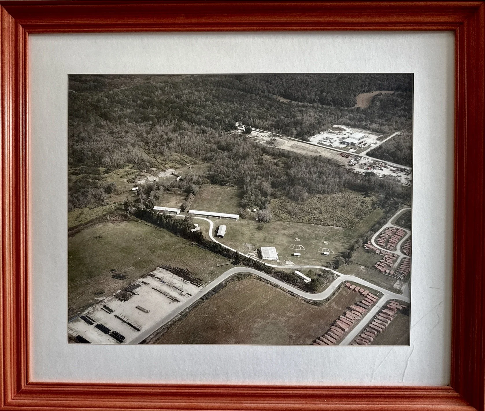 A framed black-and-white aerial photograph of the early Lakeland Rifle & Pistol Club property.