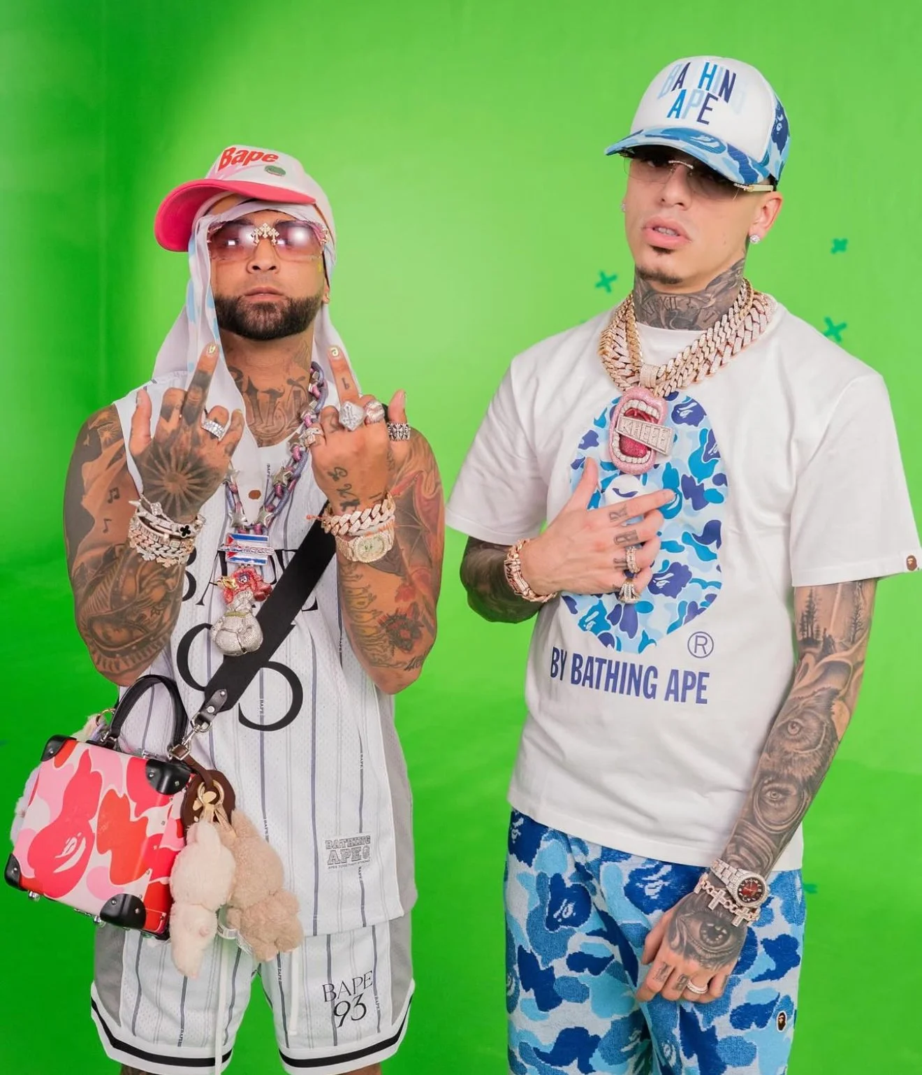 Ovi (Left) in SS25 BAPE Pink STA Trucker Hat, White Reversible Multi Logo Jersey, Shorts and ABC Pink Camo Luggage Crossbody Bag