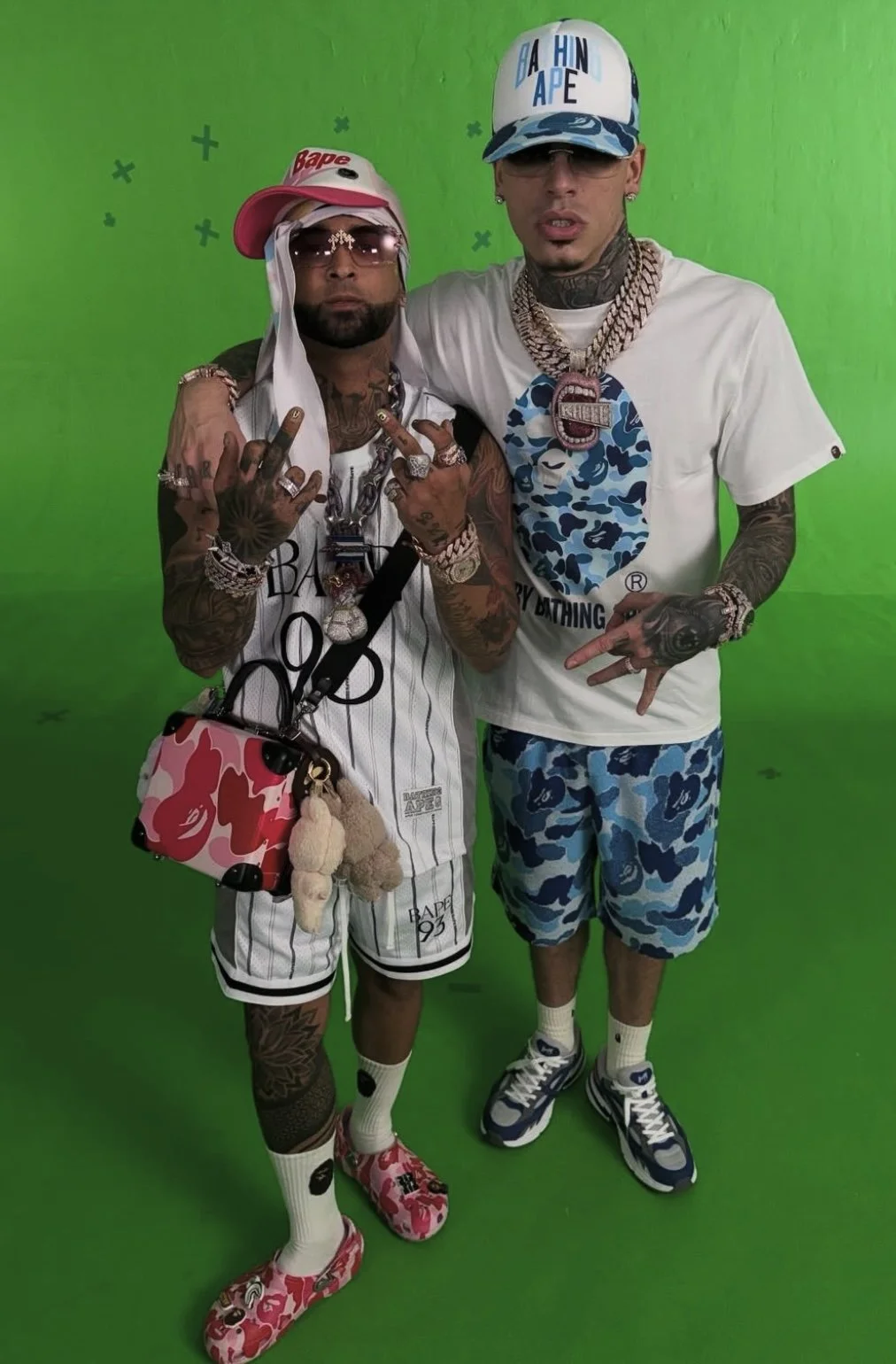 Ovi (Left) in SS25 BAPE Pink STA Trucker Hat, White Reversible Multi Logo Jersey & Shorts, ABC Pink Camo Luggage Crossbody Bag & BAPE x Crocs ABC Pink Camo Clogs