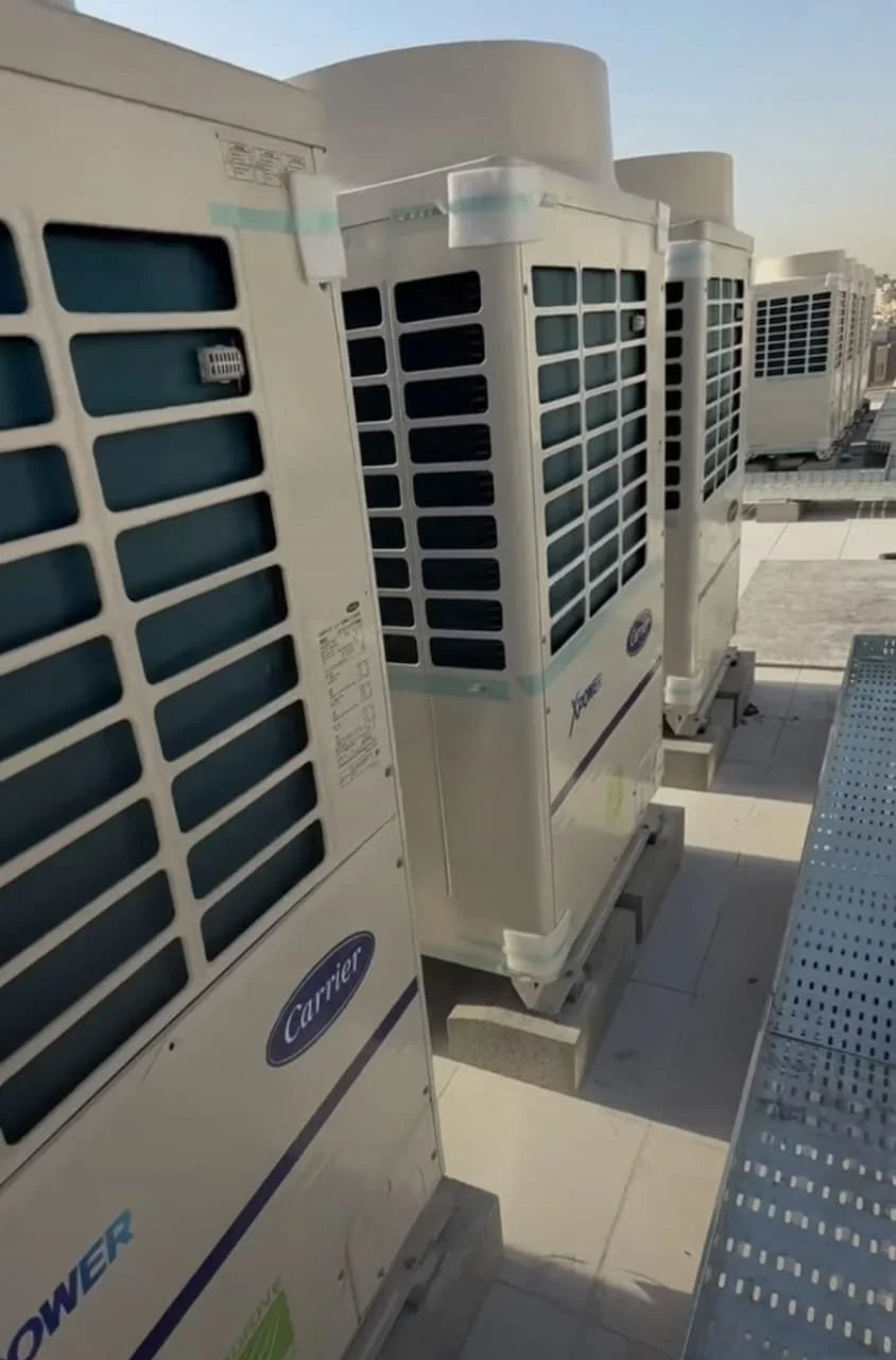 Multiple rooftop HVAC units from Carrier brand installed on a building rooftop.