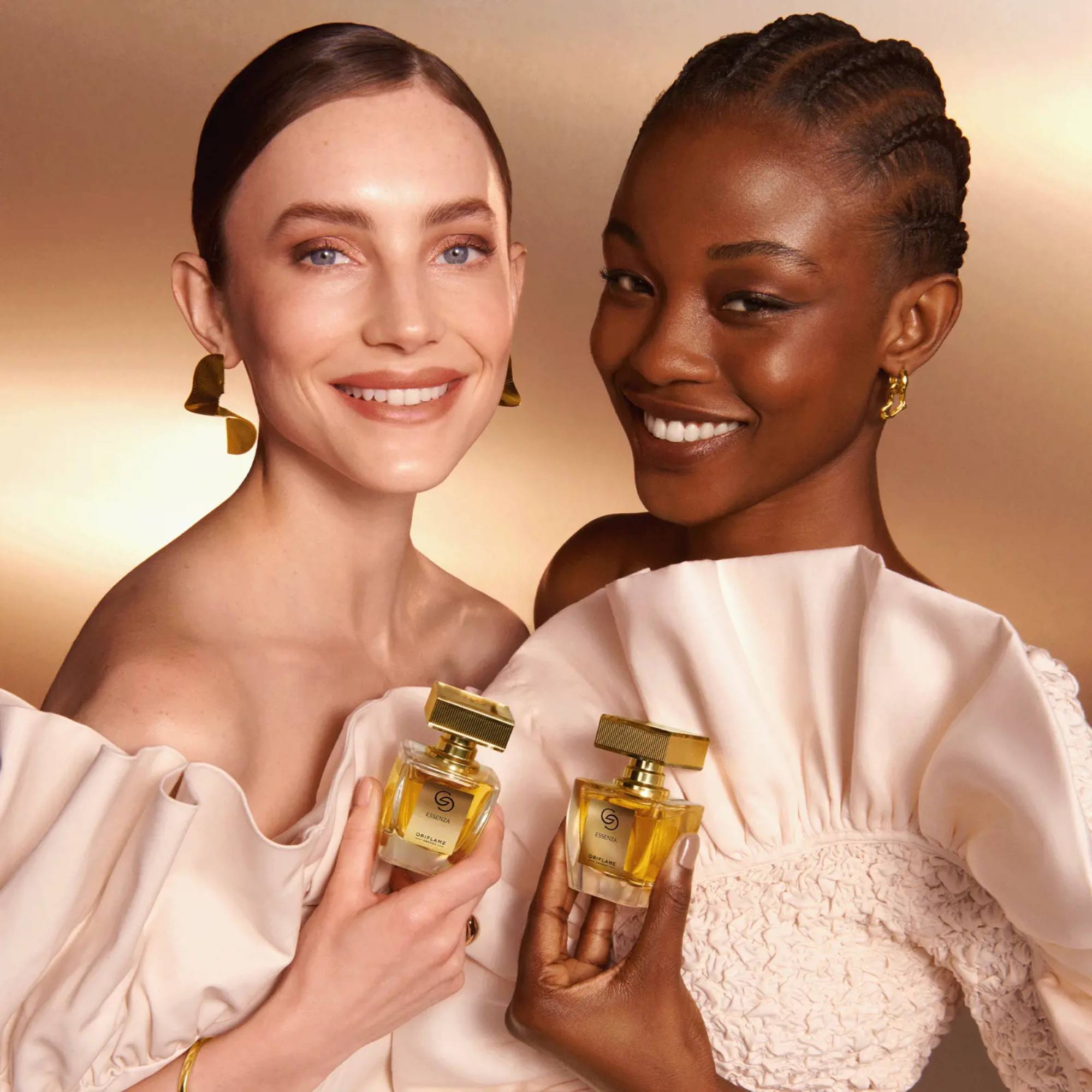 Dos mujeres sosteniendo perfumes Giordani Gold de Oriflame en un ambiente elegante.