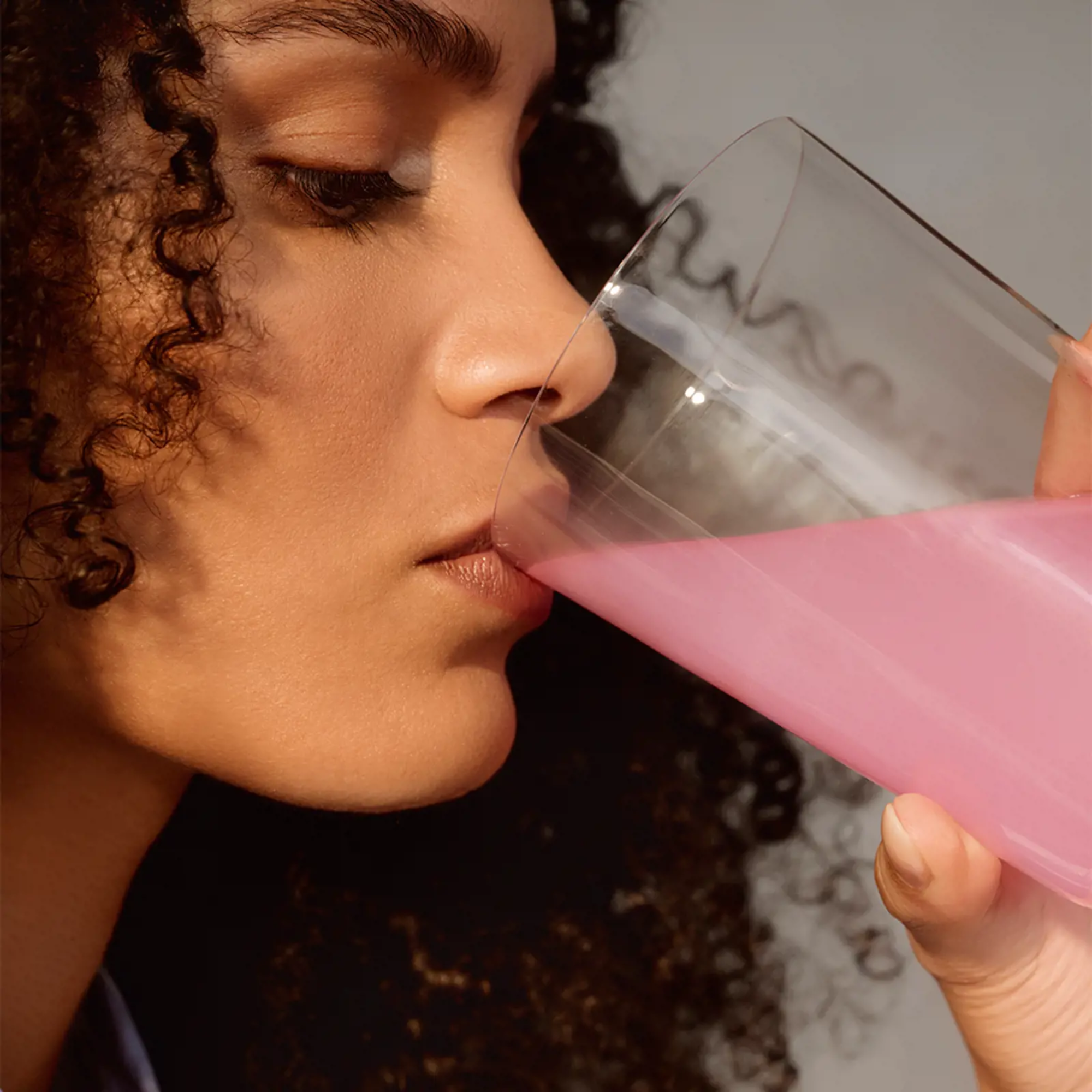 Mujer bebiendo la bebida de colágeno de Oriflame.