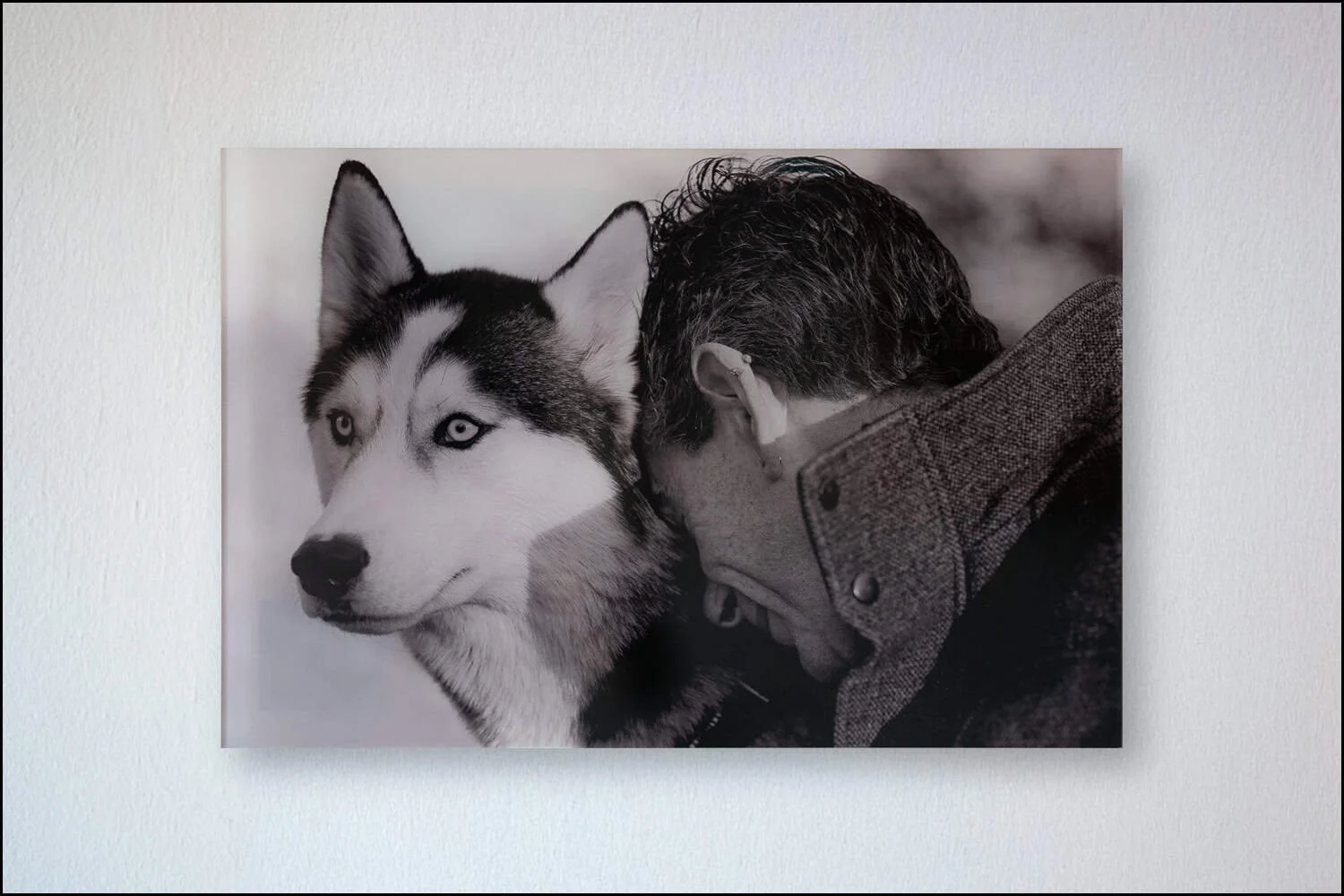 Husky and owner leaning together in black and white
