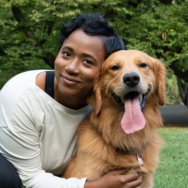 Golden retriever and lady smiling at camera