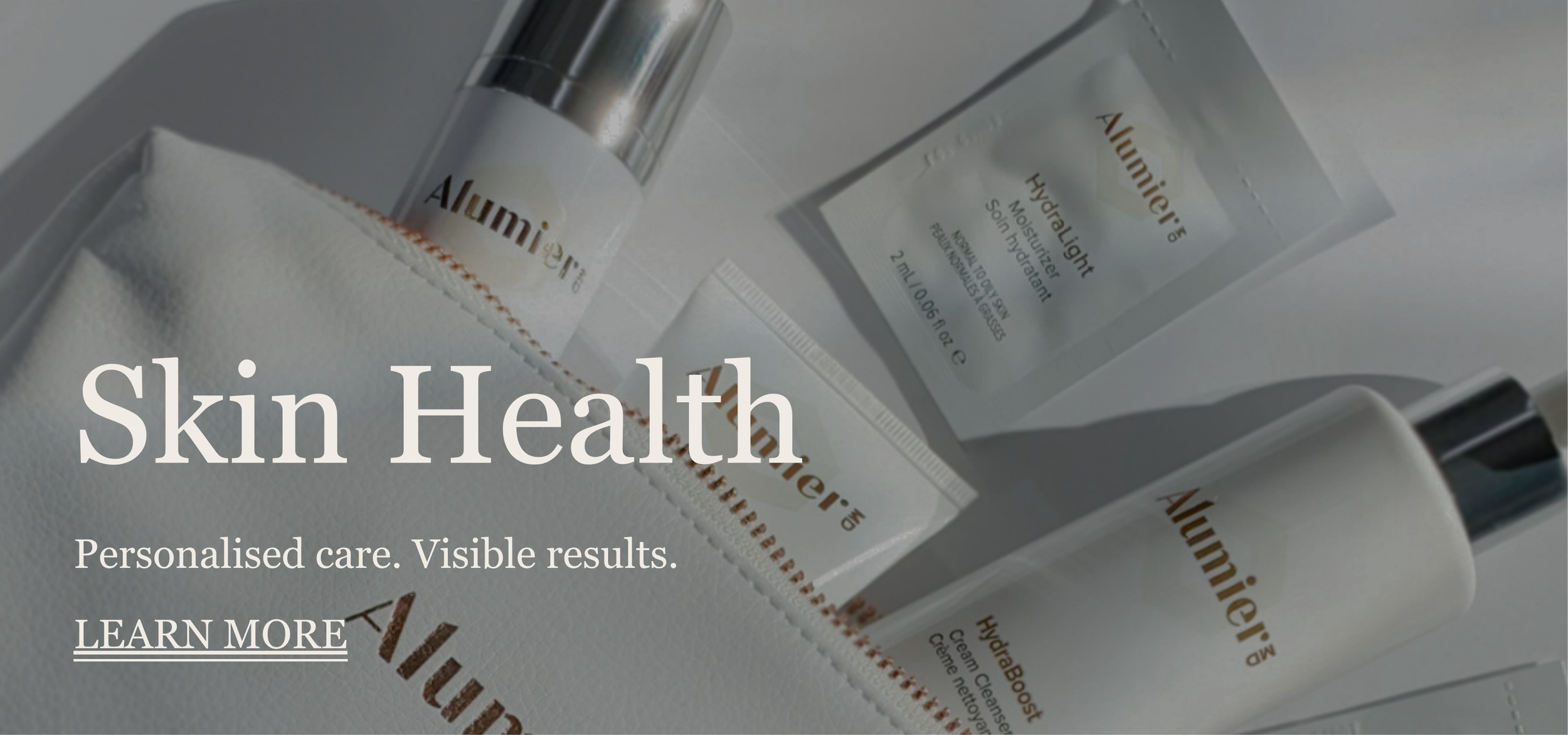 Skincare products in a white box, including lotion bottles and a packet, labeled 'Alumier,' with text overlay reading 'Skin Health: Personalised care. Visible results. LEARN MORE'.