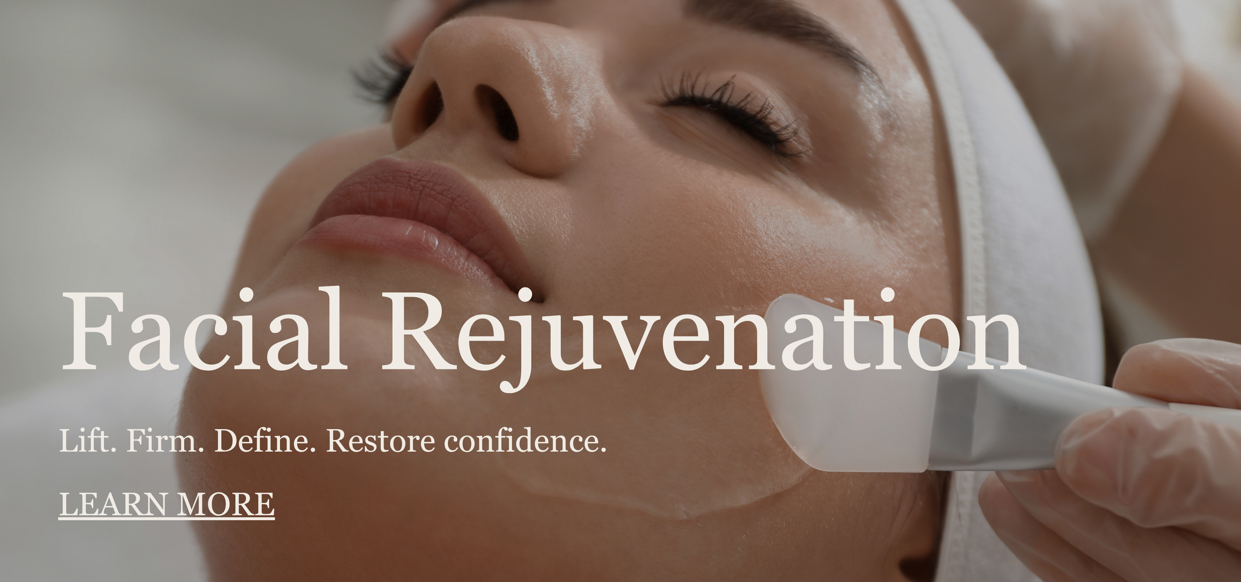 Close-up of a woman receiving a facial treatment with a skincare device on her cheek.