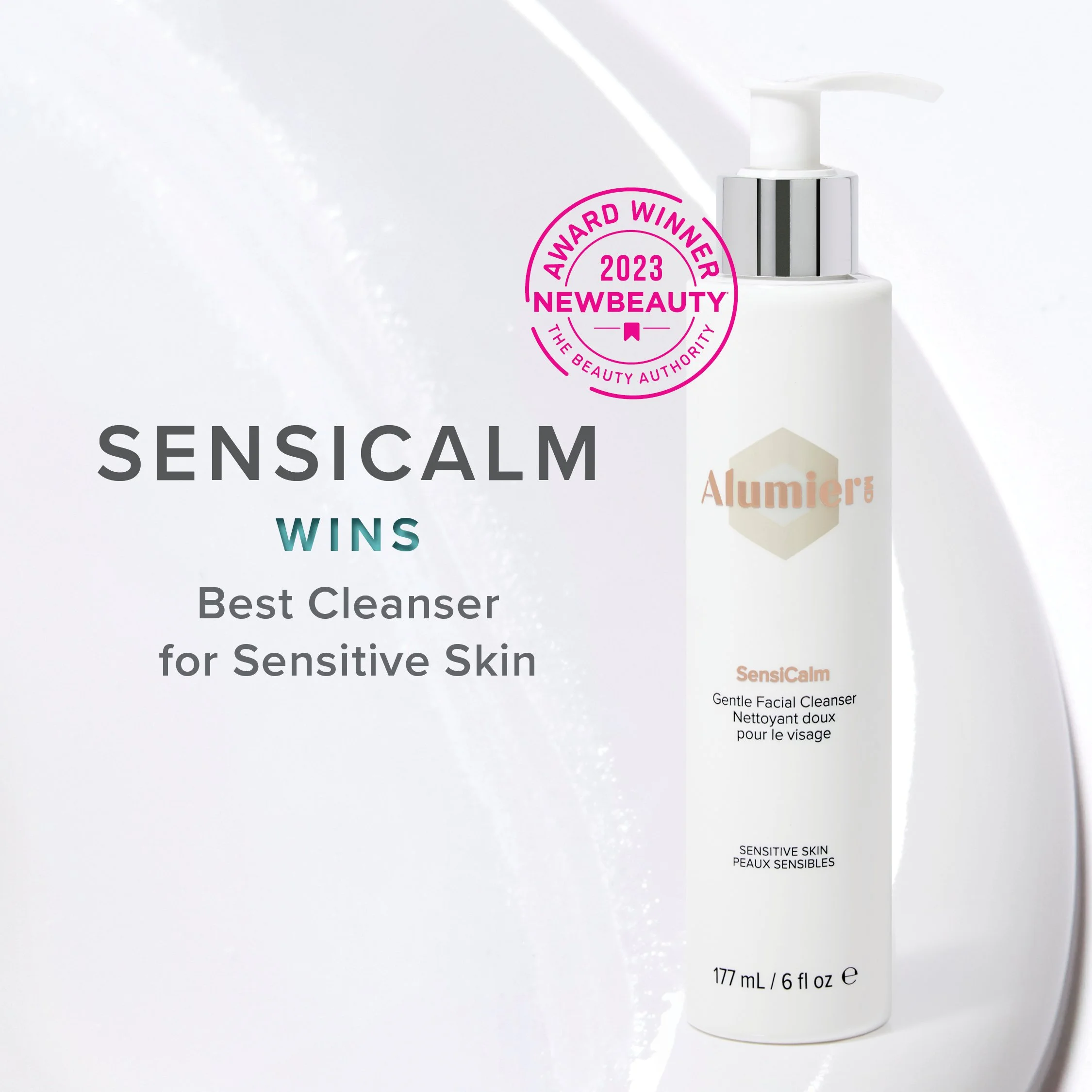 A white bottle of Alumier SensiCalm Gentle Facial Cleanser with a pump dispenser, next to a white background. The image highlights the product's award from NewBeauty 2023 for best cleanser for sensitive skin.