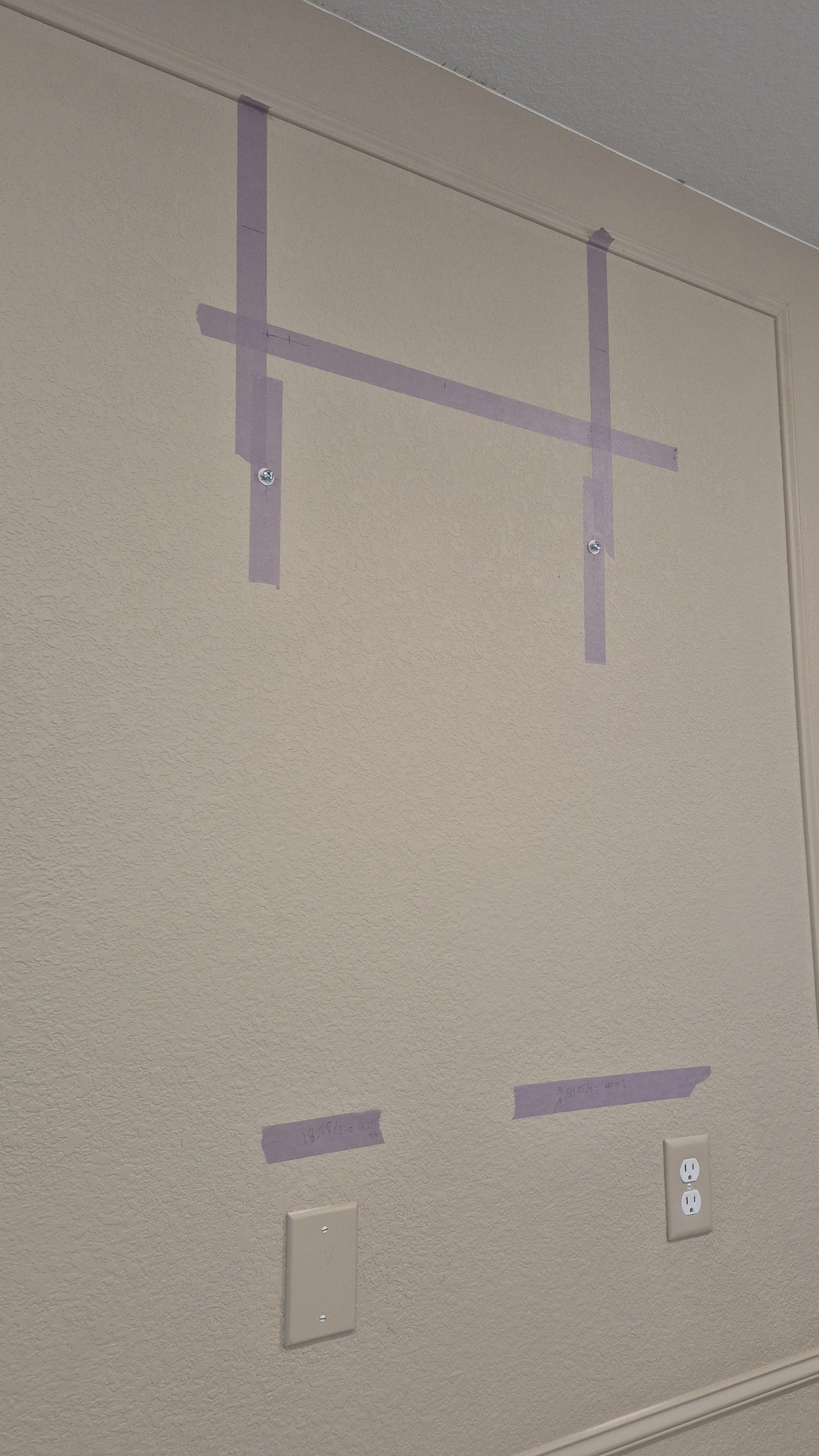 Wall with purple painter's tape marking a rectangular space, utility outlets, and a light switch; Erie, Colorado