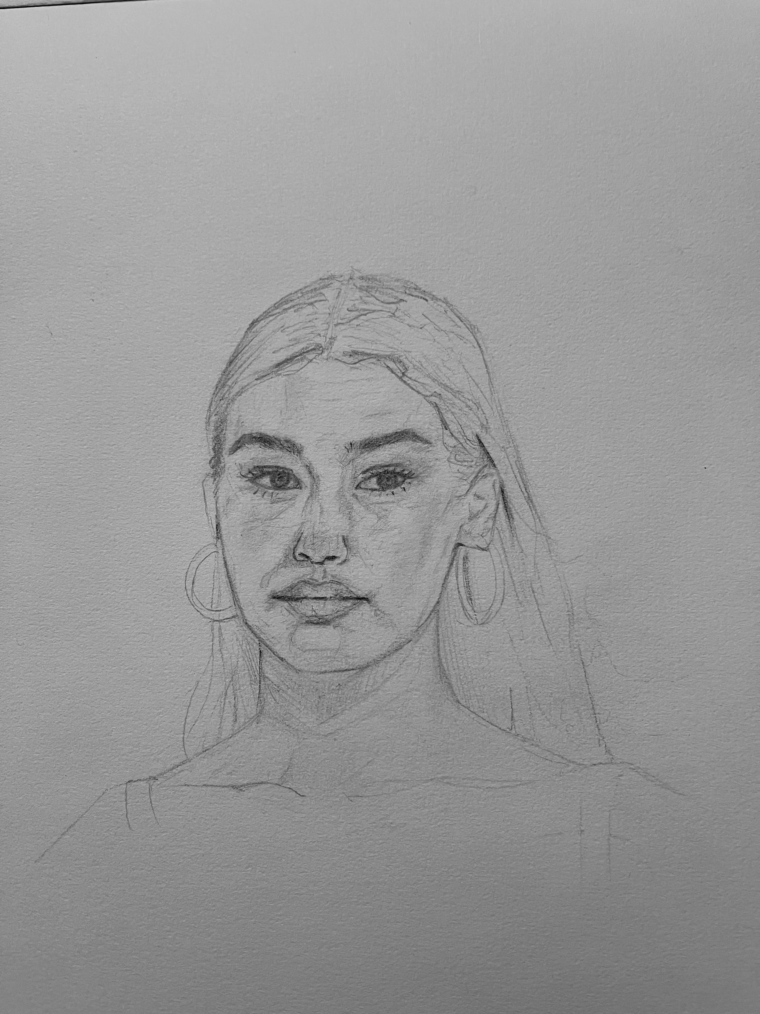 A pencil sketch of a woman's face with large hoop earrings, almond-shaped eyes, and long hair, on textured paper.
