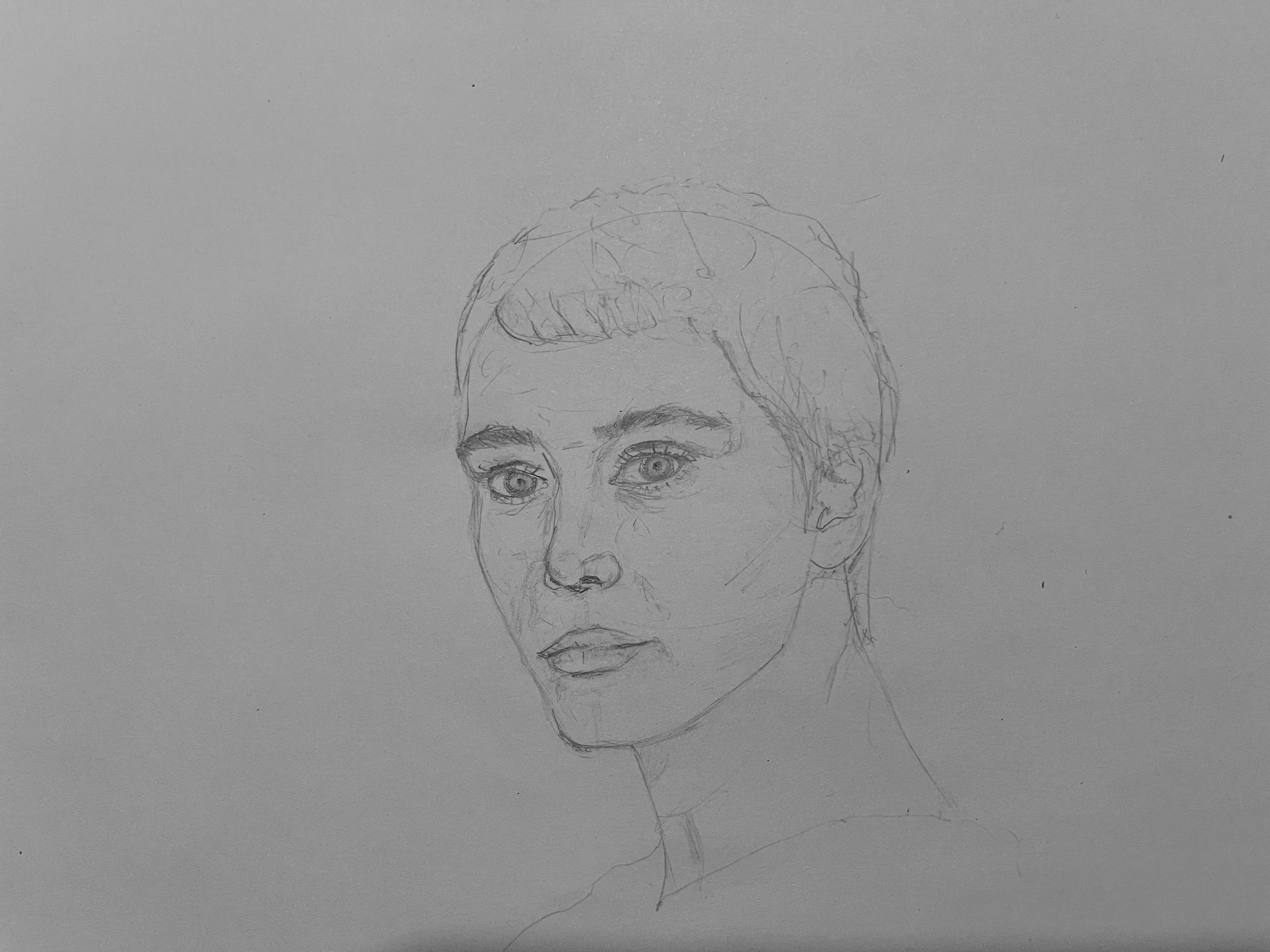 A pencil drawing of a person's face with detailed eyes, eyebrows, nose, and lips, partially visible on a blank sheet of paper.