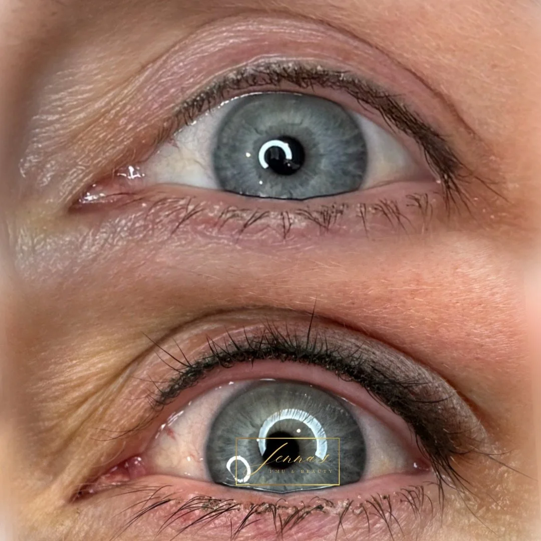 Close-up of a person's gray eyes with makeup, showing the upper and lower eyelids, eyelashes, and skin details.