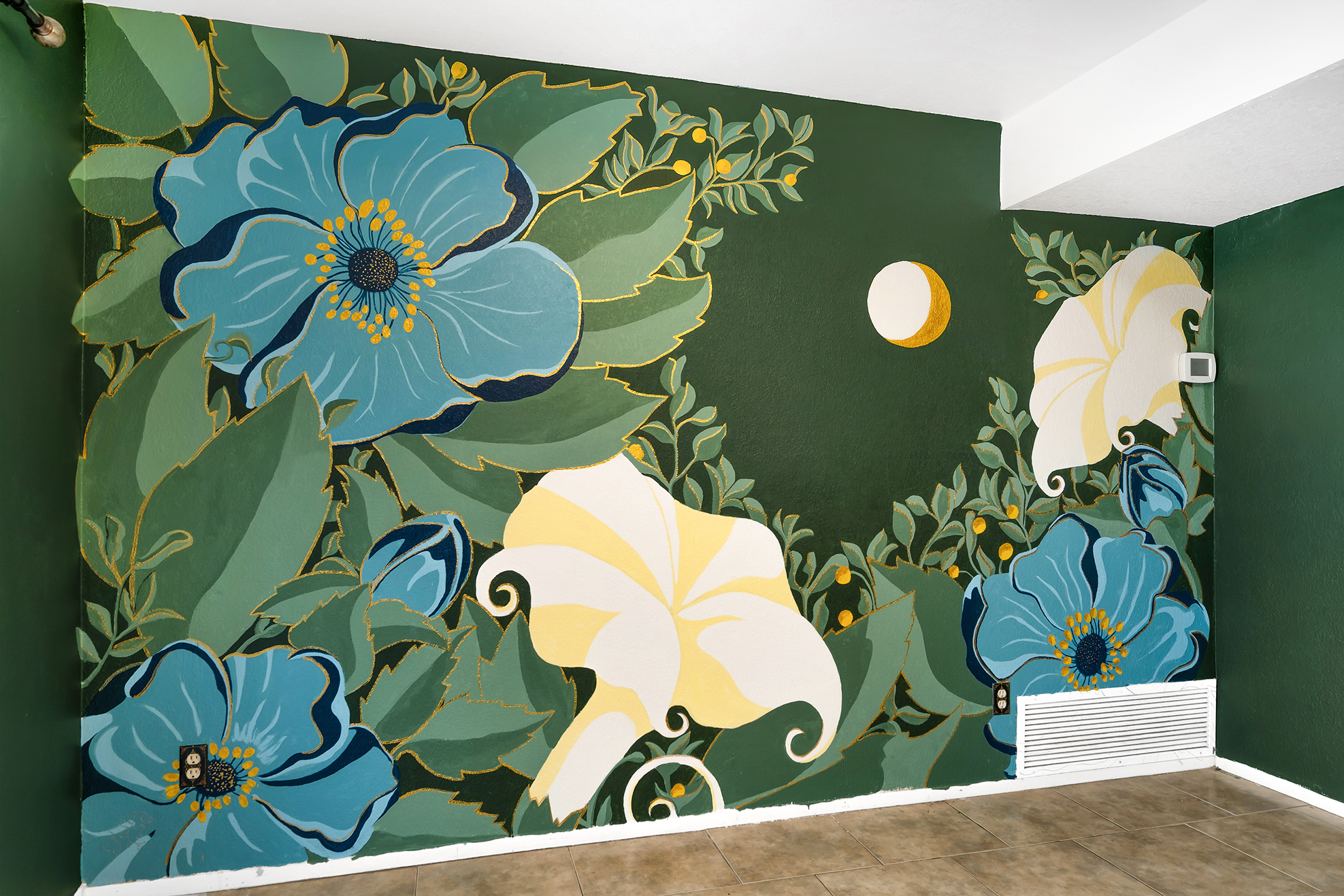 A colorful floral mural on a green wall featuring large blue and white flowers with yellow accents, green leaves, and a small yellow moon or circle, in an indoor space.