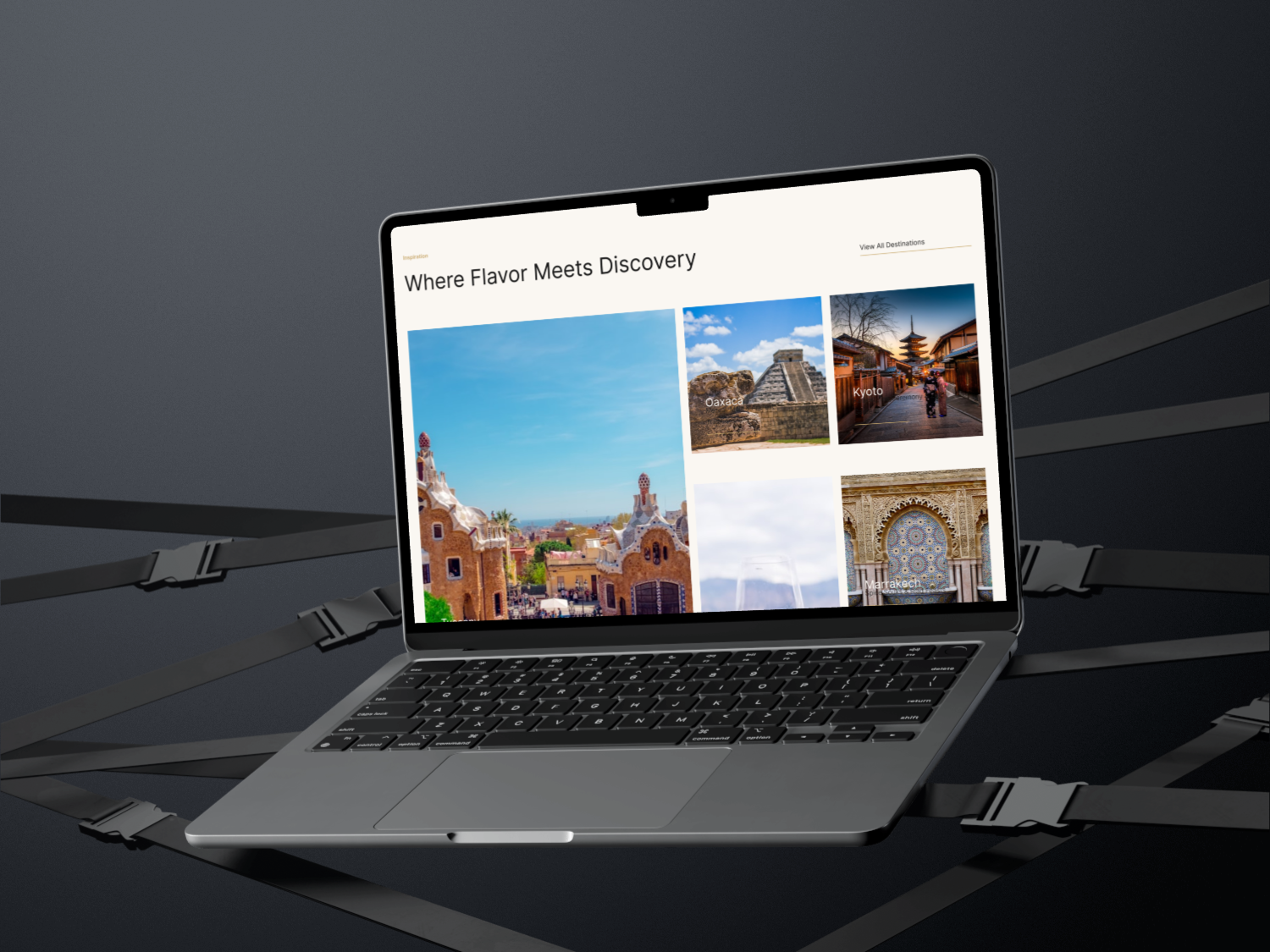 A laptop on a dark surface displaying a travel website titled 'Where Flavor Meets Discovery' with images of architecture and landmarks from Oaxaca, Kyoto, and Marrakech.