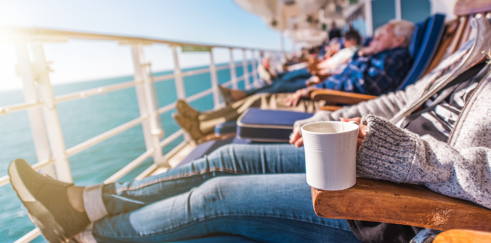 People sitting on deck on cruise ship with coffee