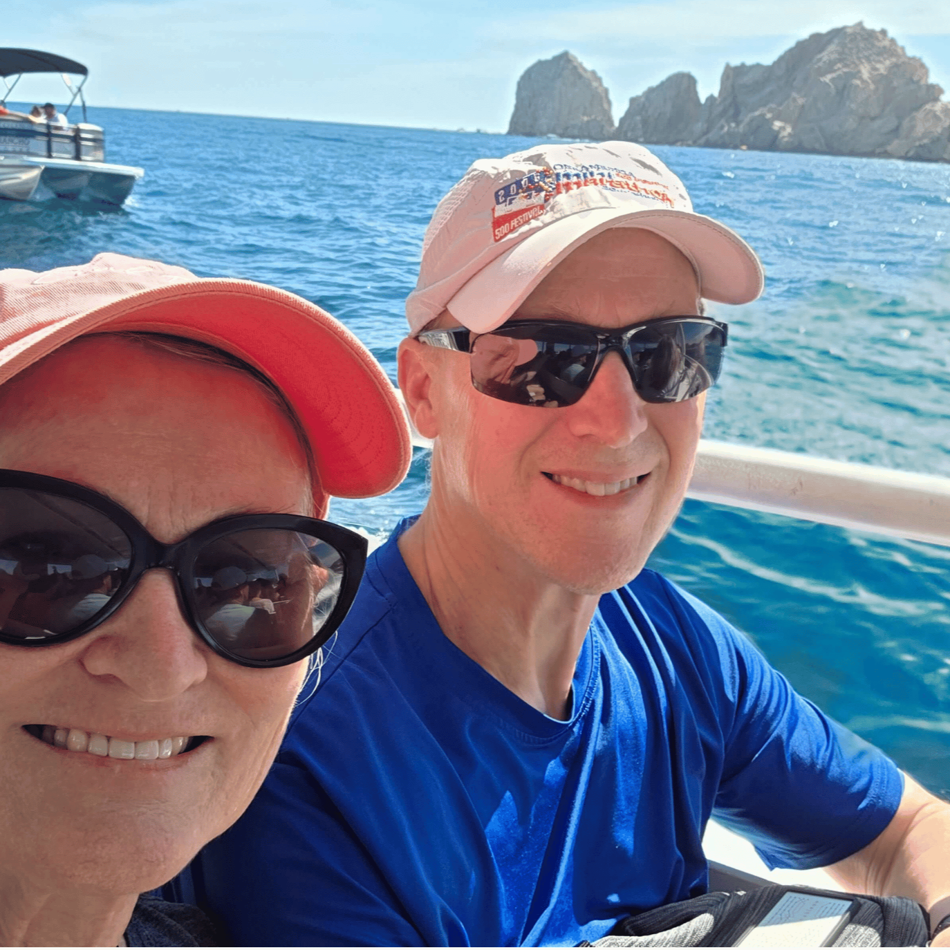 Laura Varnau, travel agent with Wishes and Waves Travel, on a boat with her husband with blue water and cabo san lucas in the background