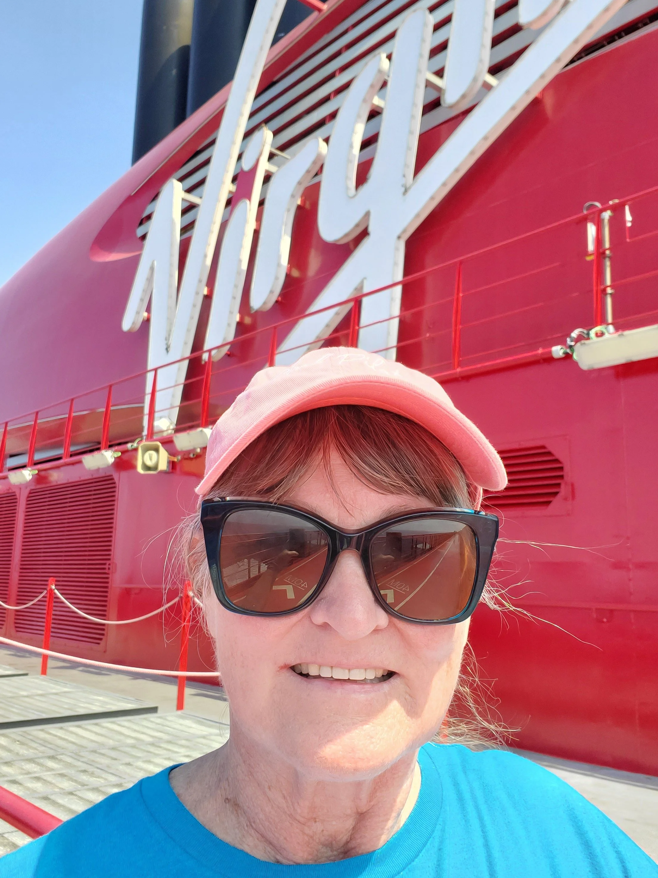 Laura Varnau, travel agent with Wishes and Waves Travel, wearing ball cap and sunglasses on Virgin Voyages walking track