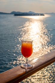 Cocktail sitting on railing on cruise ship deck