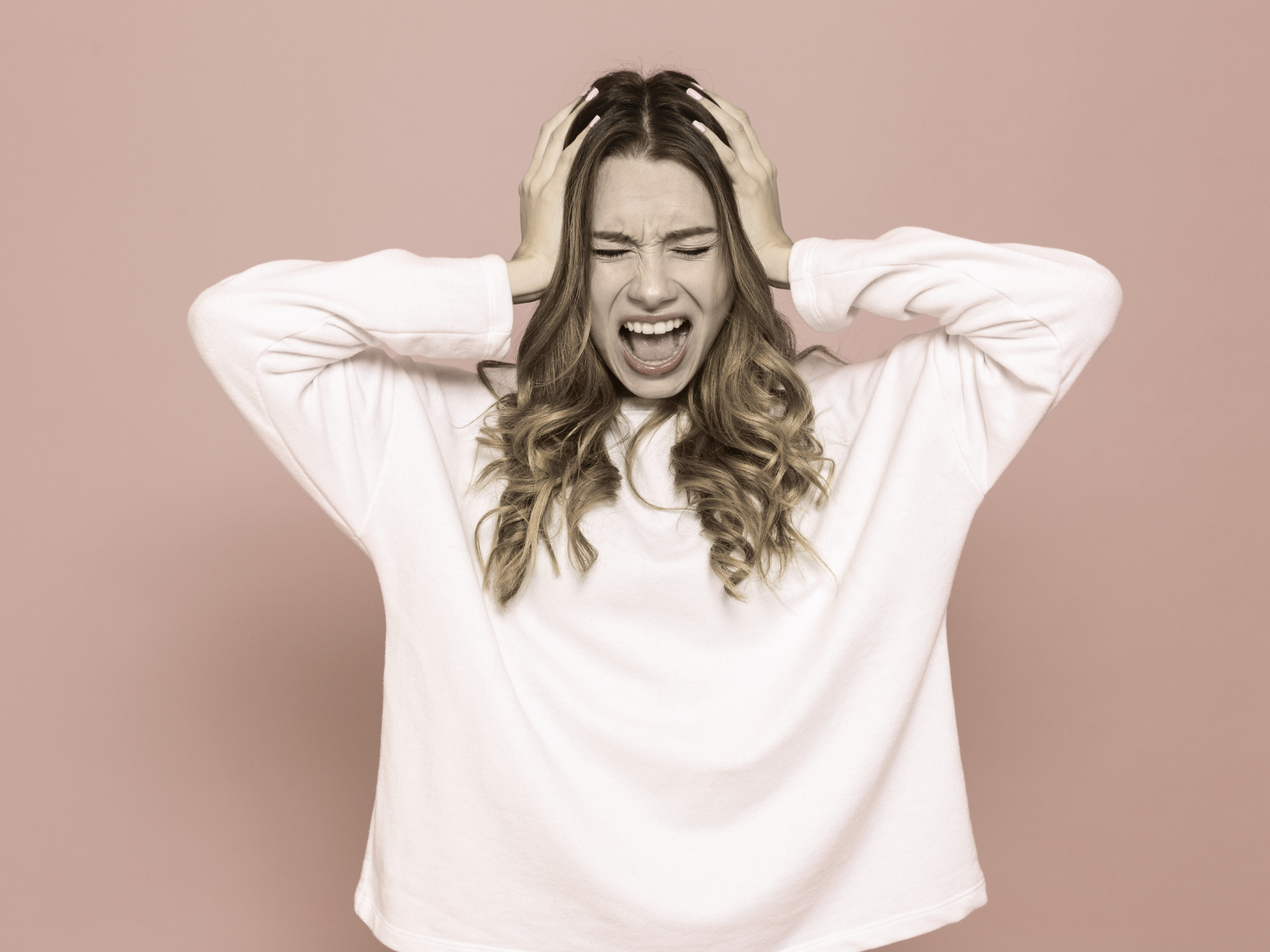 Frustrated woman yelling with hands on her head