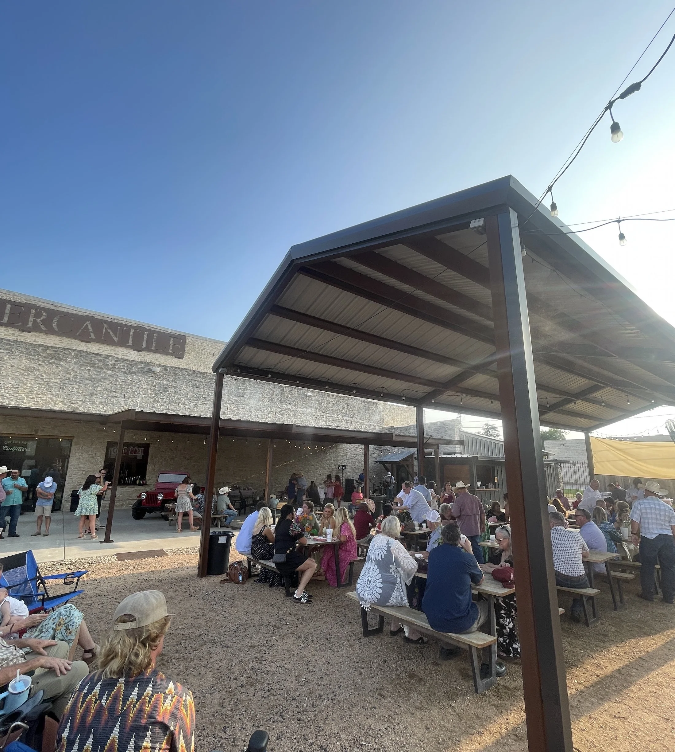 Guests dining under string lights in the Green Canoe beer garden