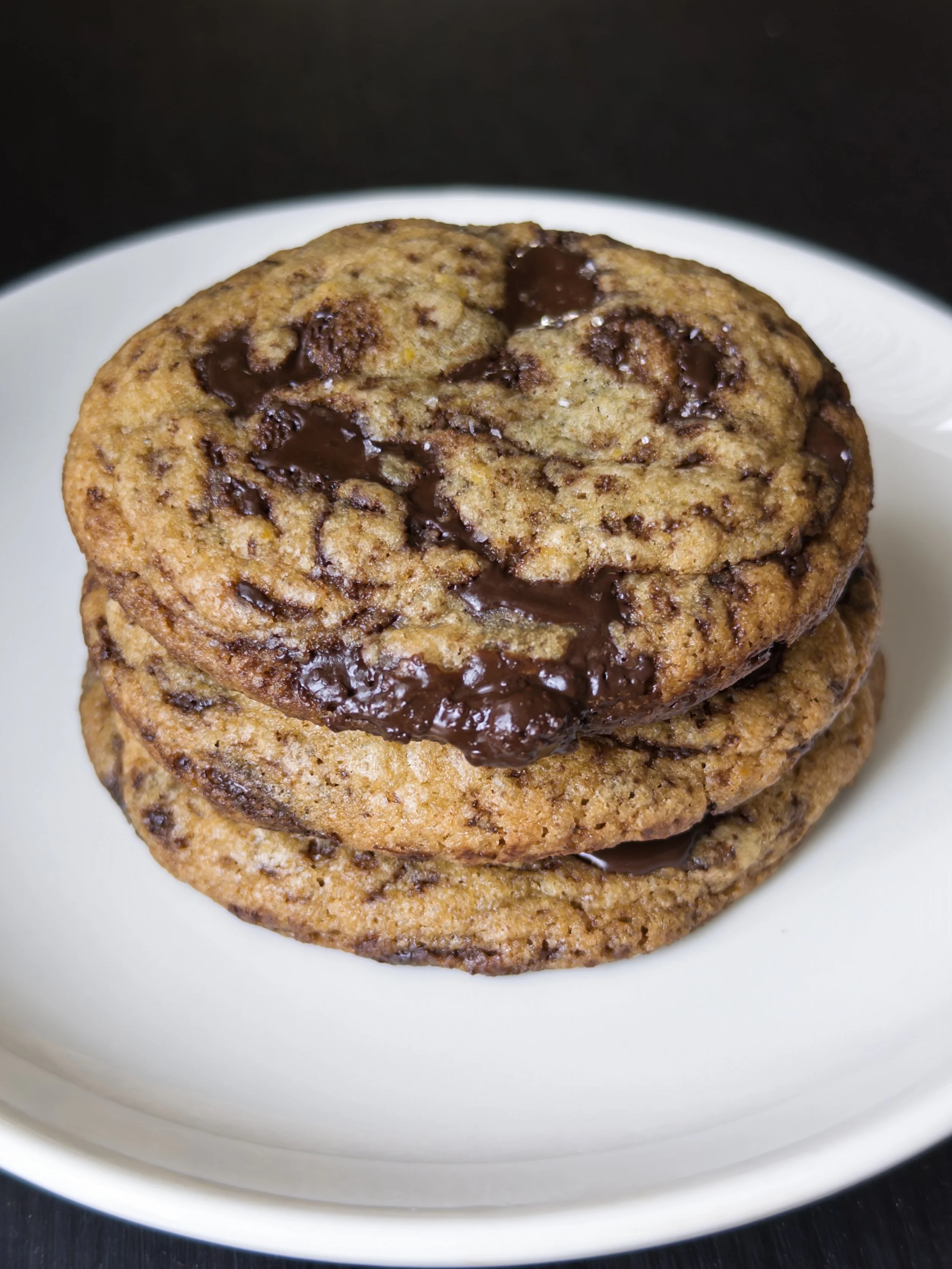 Close-up of two chocolate chip cookies stacked on a white plate.