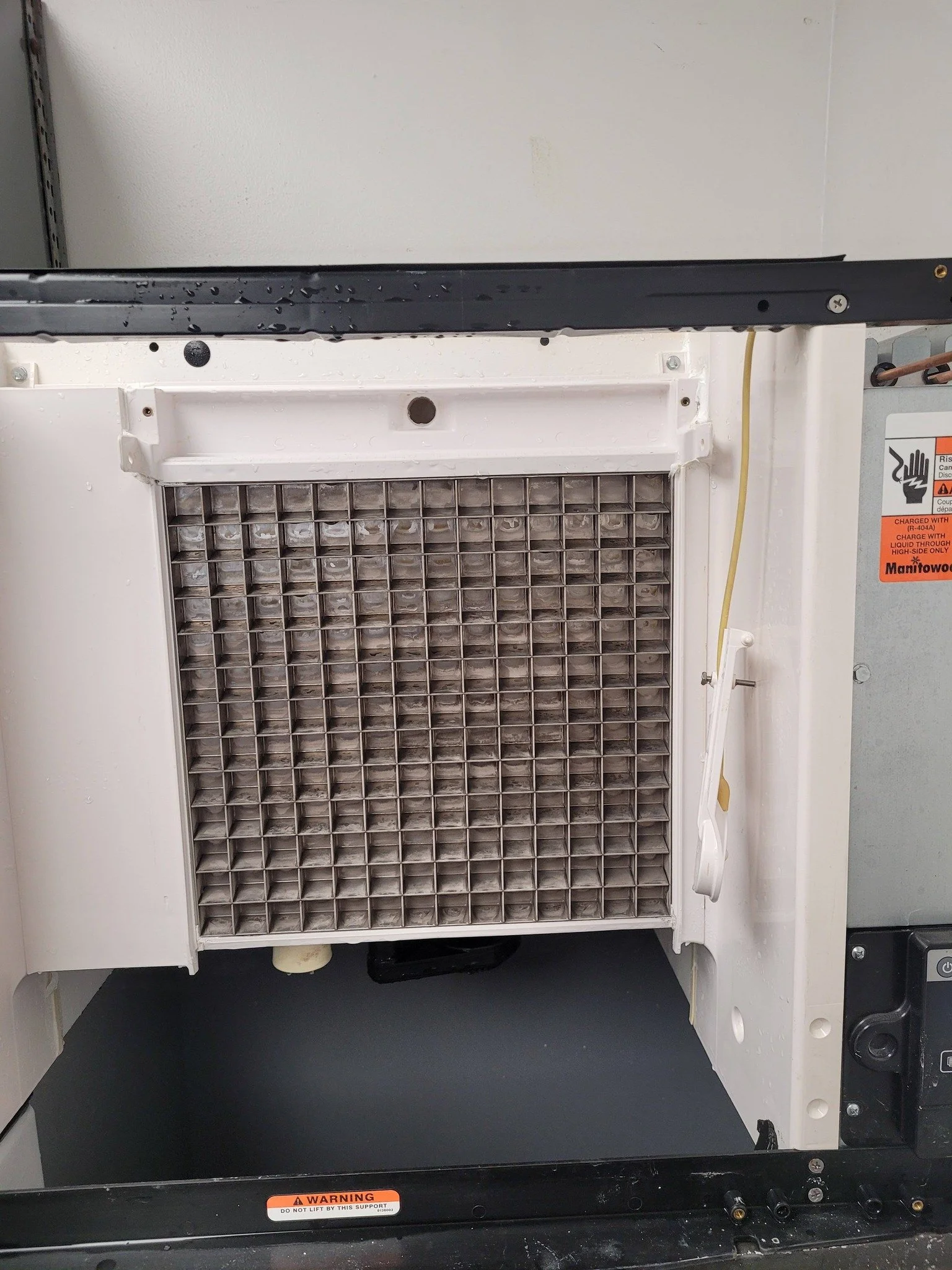 Before and after comparison of a commercial ice machine showing heavy buildup removed and surfaces fully cleaned and sanitized.