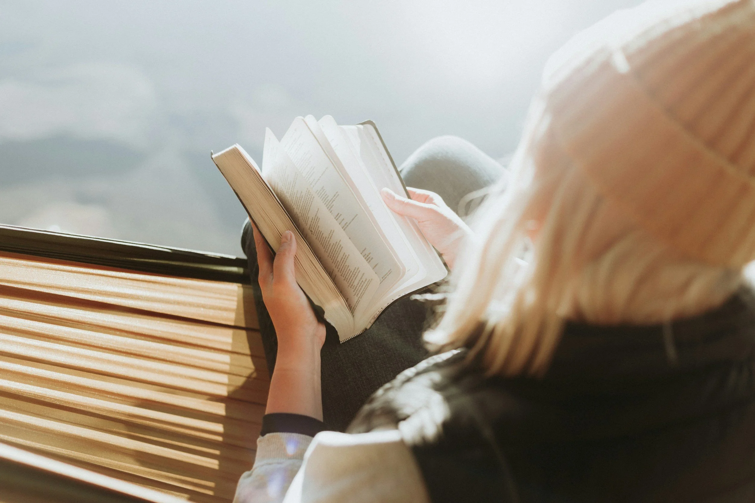 Woman sitting and flipping through her Bible