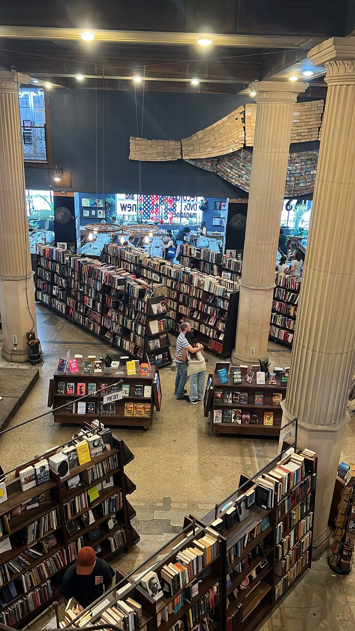 Interior of a large bookstore with tall bookshelves and columns, and customers browsing books.