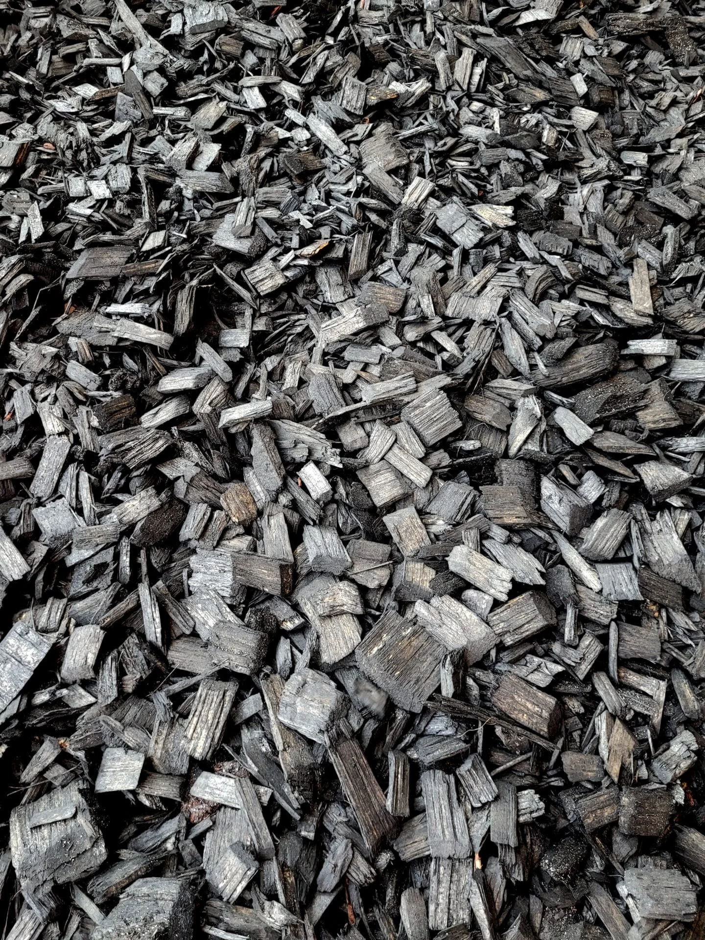 Close-up of a large pile of black wood chips or mulch.