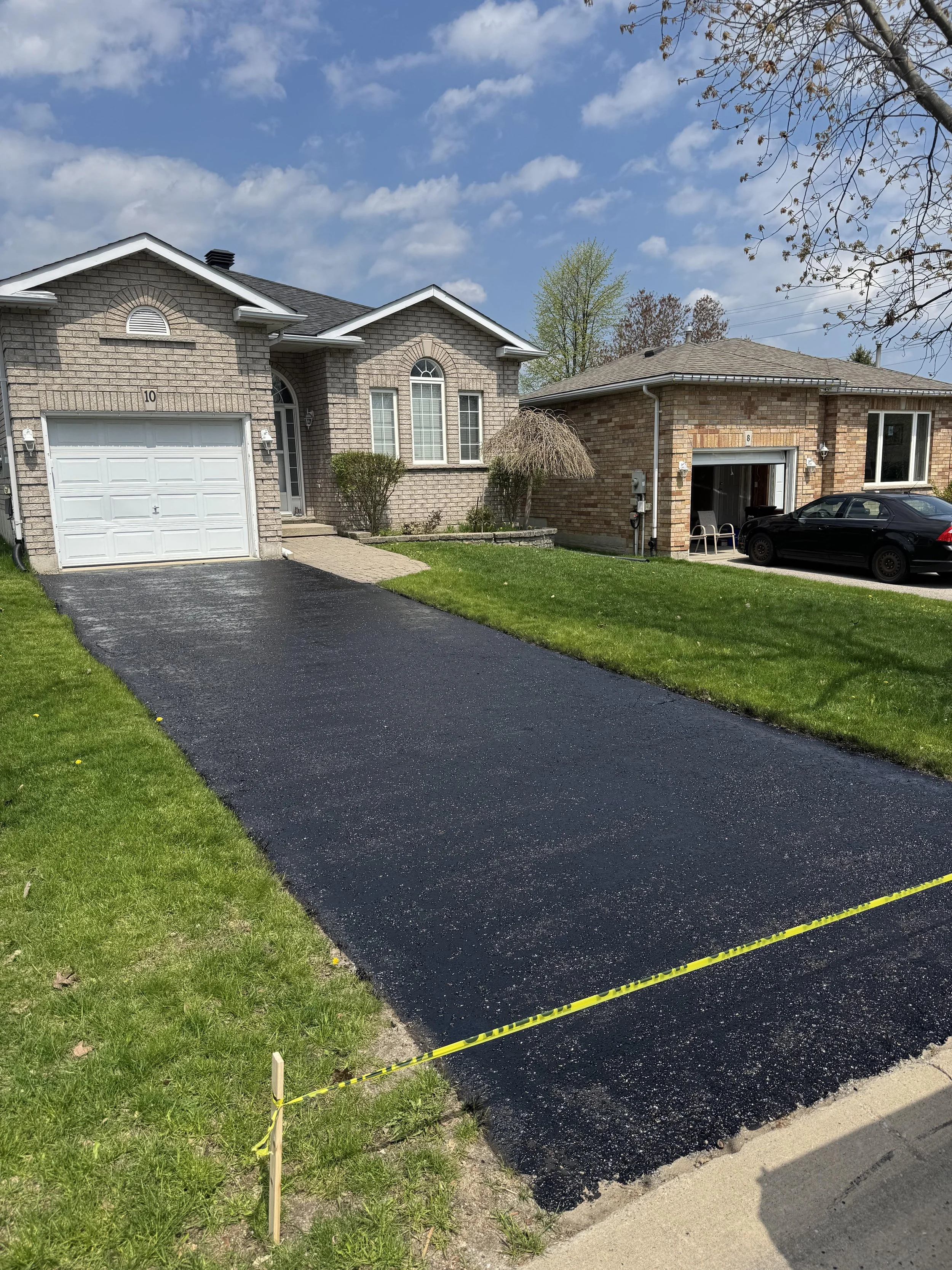 Professional driveway sealing service on a residential asphalt driveway in Barrie, Ontario