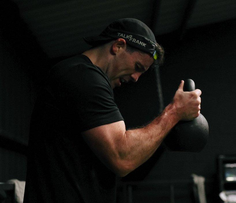 Personal trainer in Liverpool performing a kettlebell strength exercise during a coaching session.