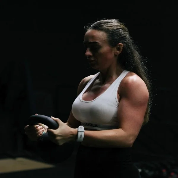 Personal trainer coaching a client through a kettlebell exercise in a gym