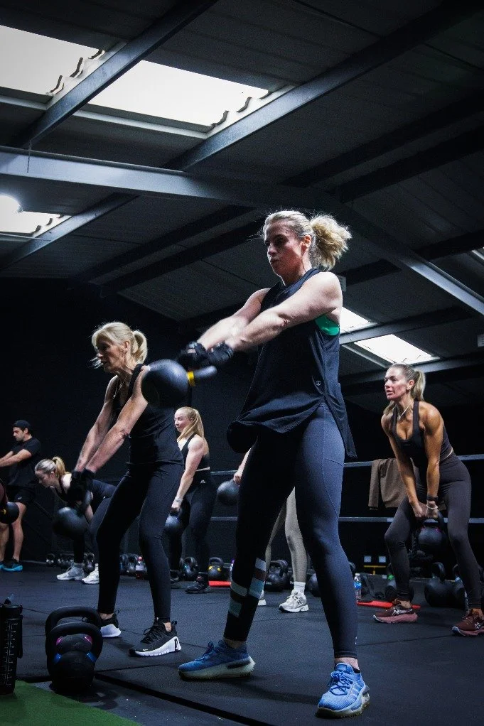 Members performing kettlebell swings in group classes in Liverpool
