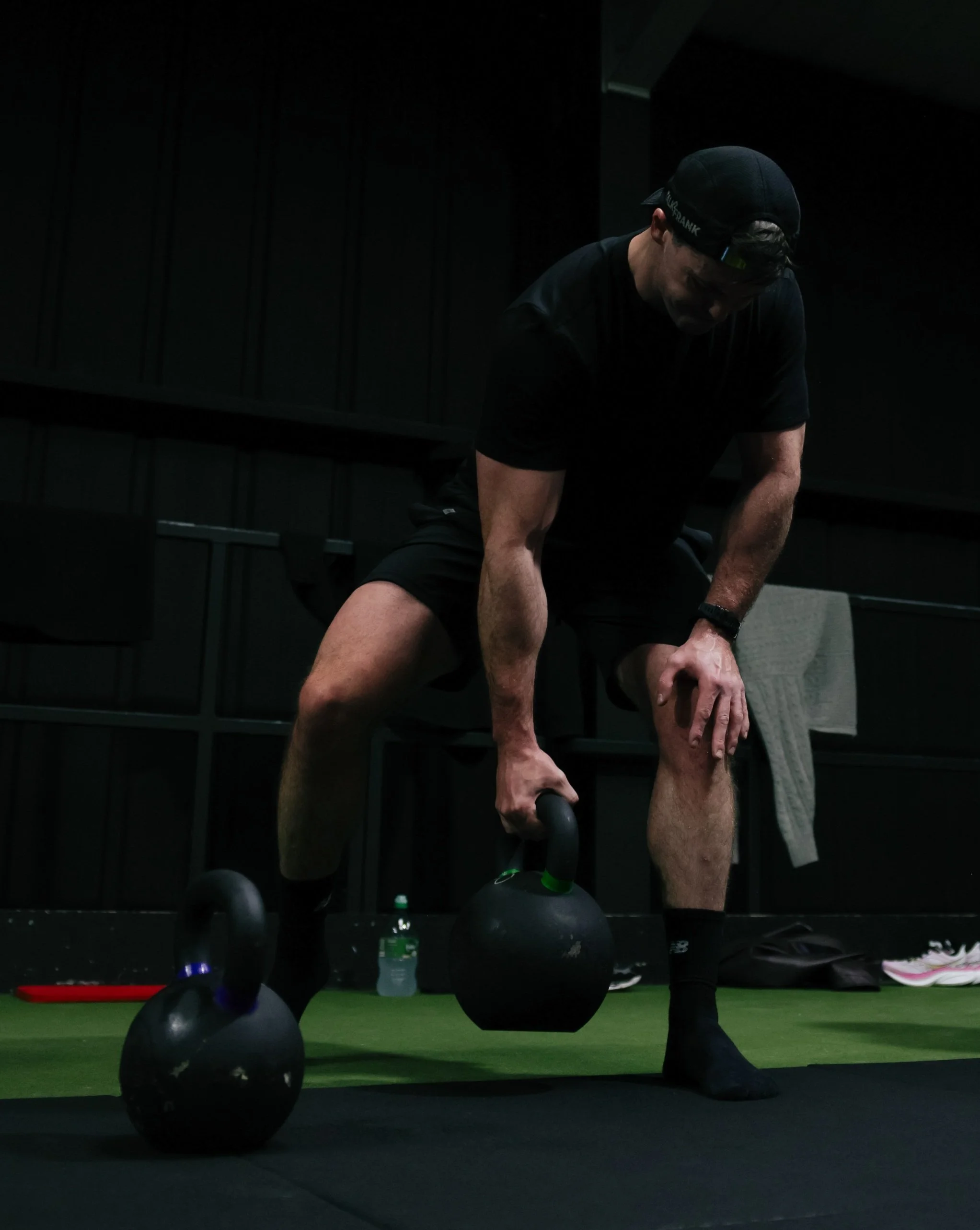 Man performing kettlebell deadlift with proper hip hinge technique in gym