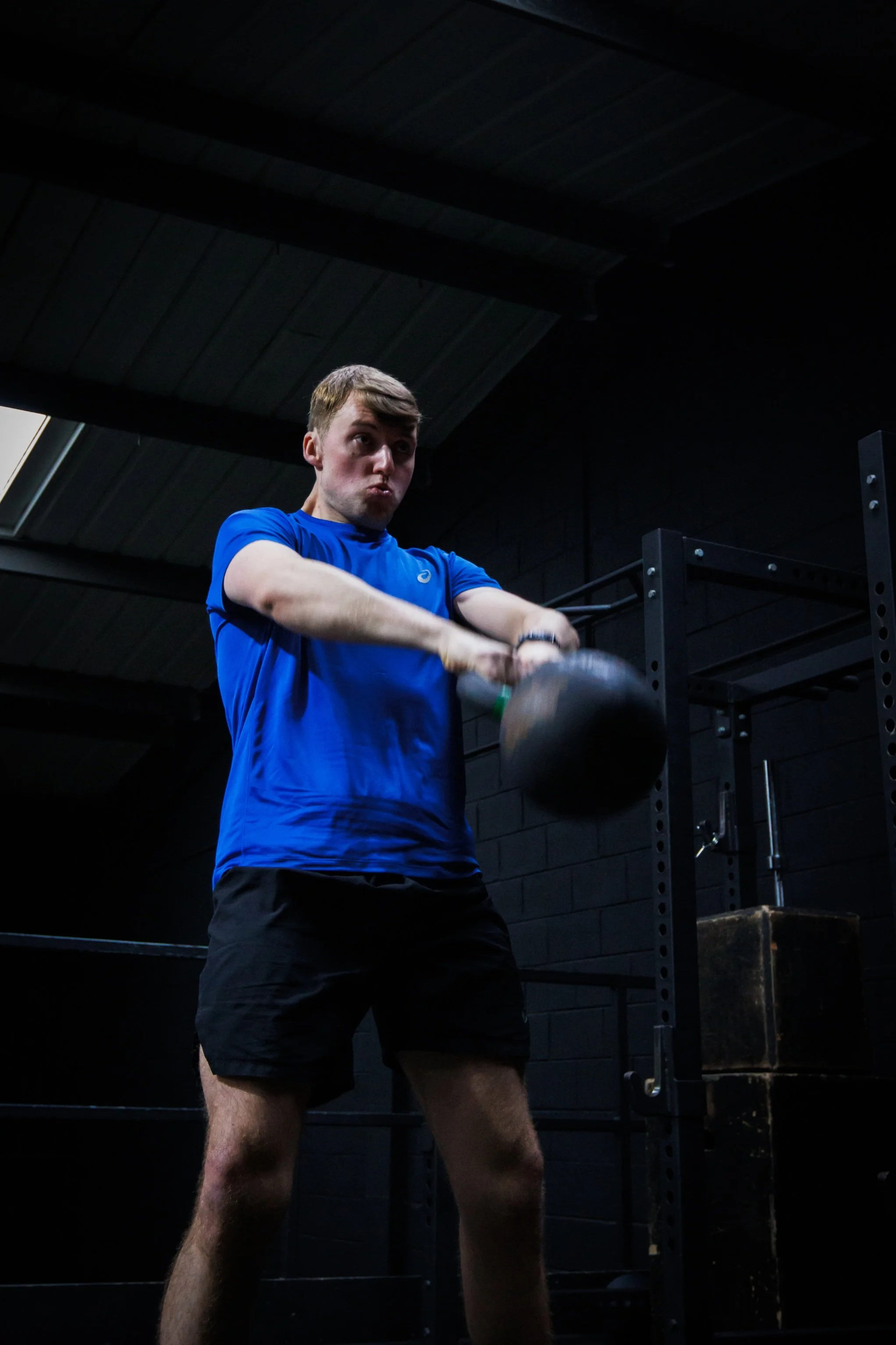 Liverpool personal training client performing kettlebell swing during coached gym workout