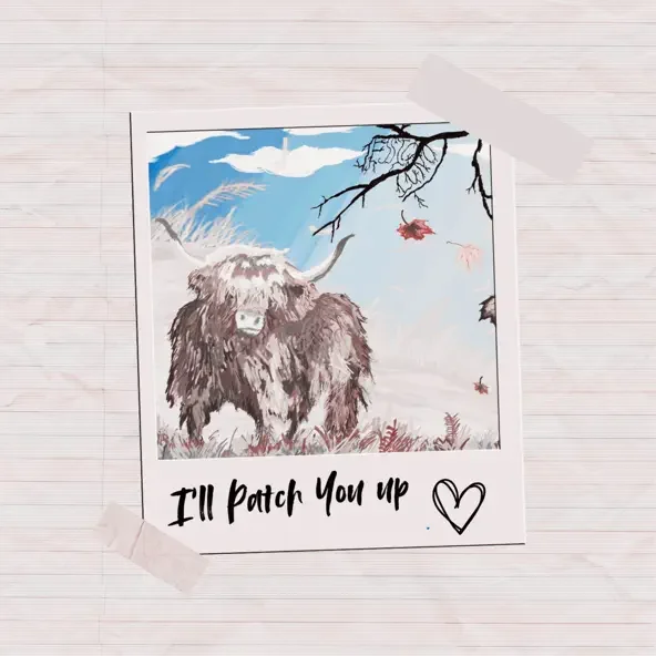 A printed photograph of a Highland cow in a winter landscape, with a tree branch and falling leaves. Text at the bottom says 'I'll patch you up' with a heart drawing.