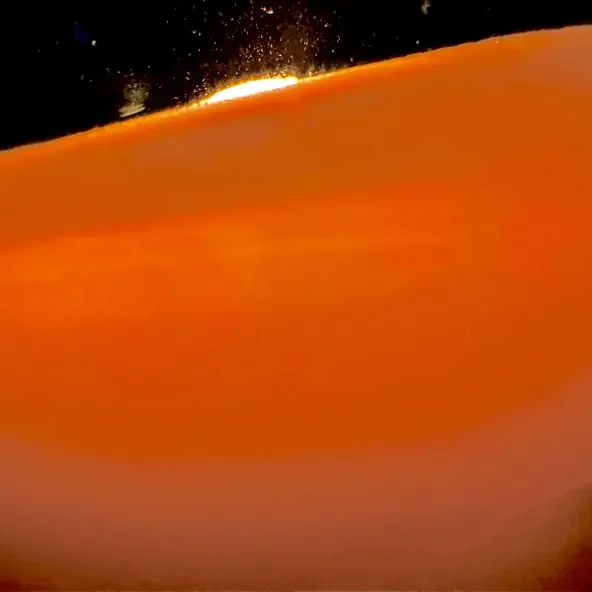 A sunset over a desert landscape with orange dunes and a dark sky.