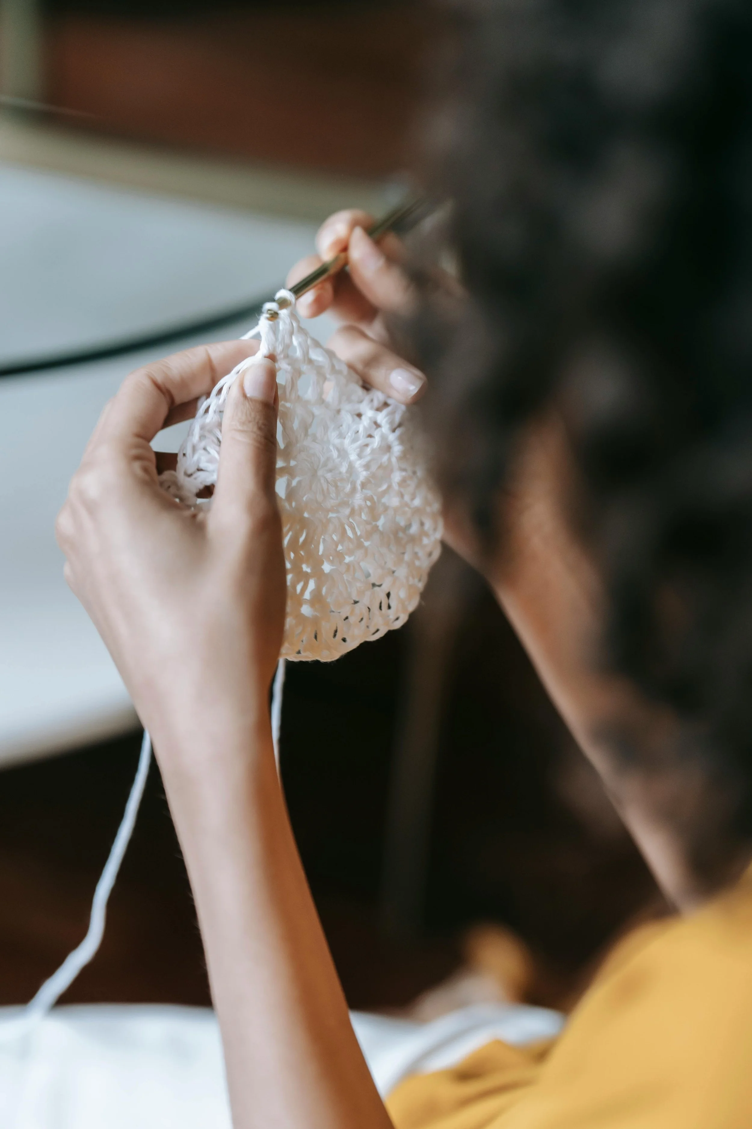 Personne faisant du crochet avec une pièce en fil blanc.