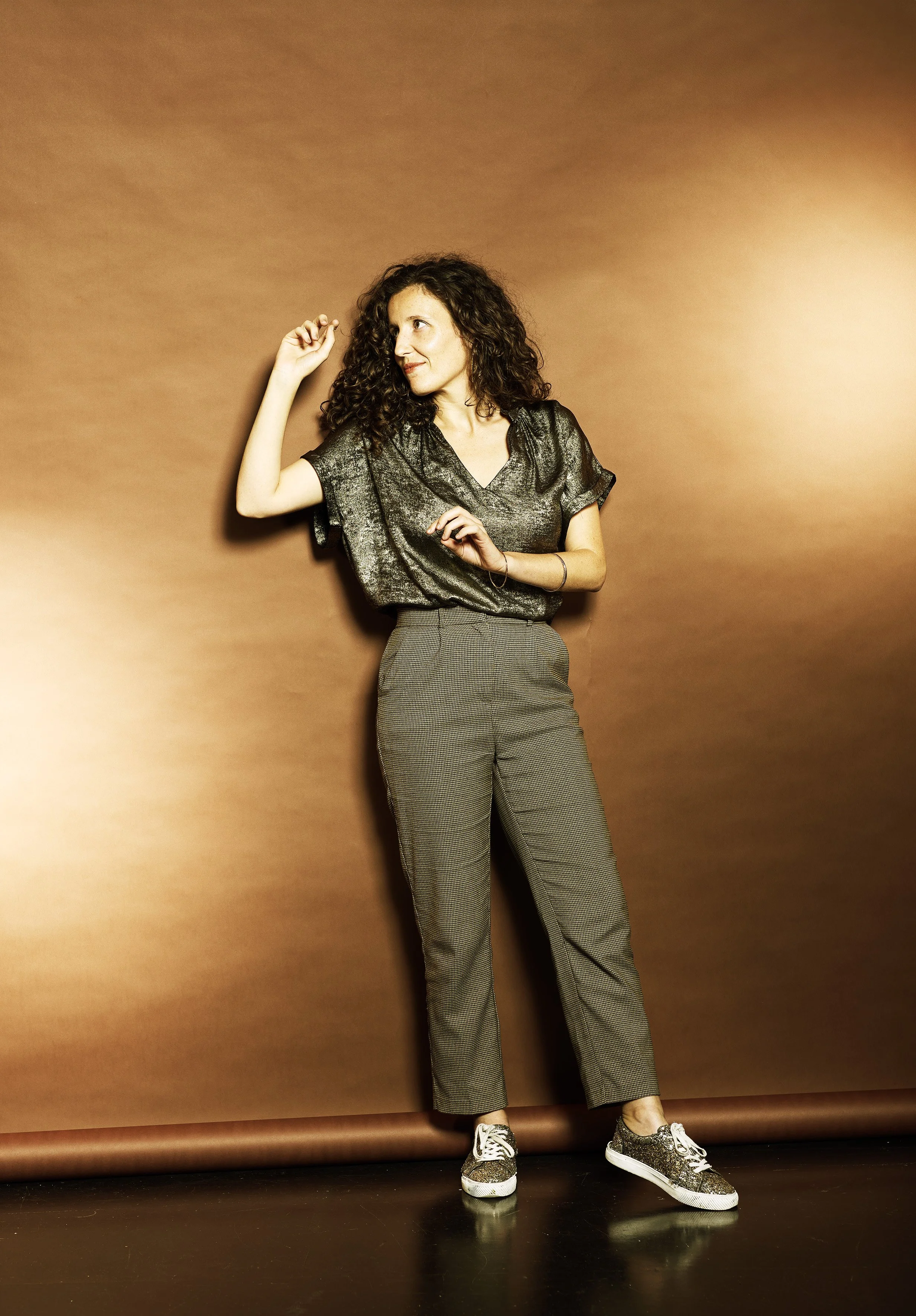 Close-up portrait highlighting the golden mechanics of the concert harp with Louisic Dulbecco on a copper backdrop
