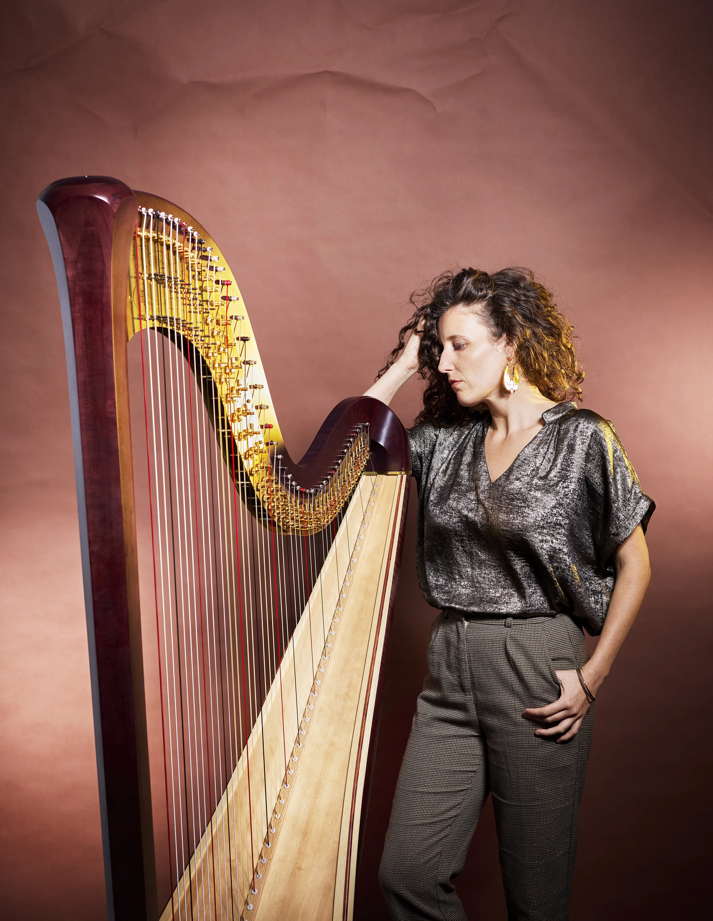 Louisic Dulbecco standing against a copper-toned studio backdrop, casual pose
