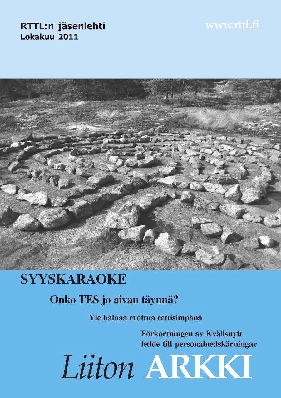 "Liiton Arkki" kansilehti, Lokakuu 2011, sinisellä taustalla mustavalkoinen kuva kivestä ja maasta.