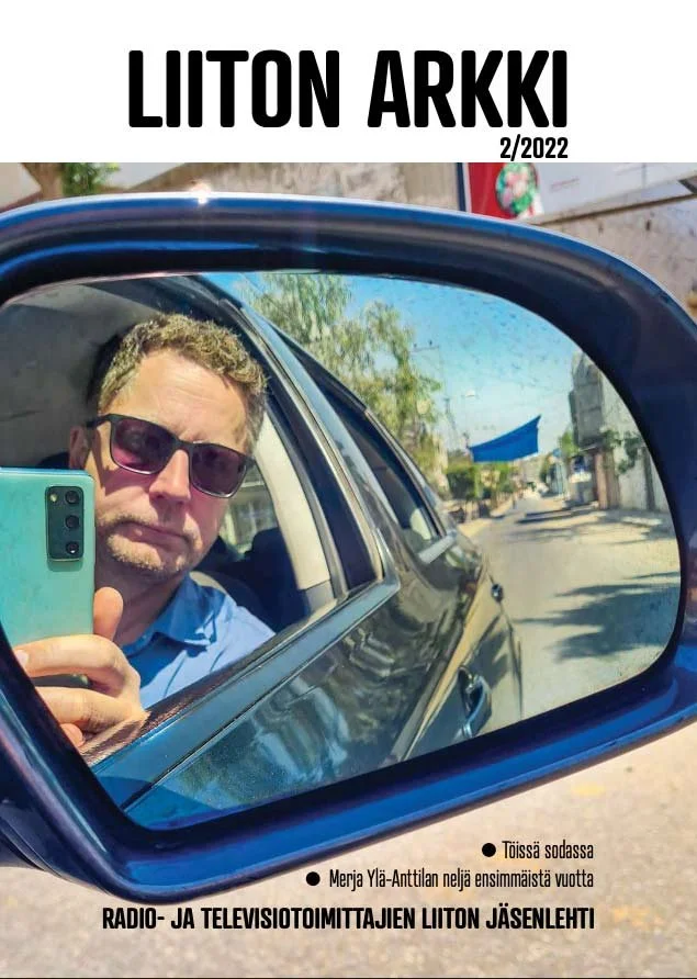 kuvassa valokuva miehestä, joka ottaa puhelimella kuvaa auton ikkunan kautta itsestään, miehellä on aurinkolasit ja sininen paita. "Liiton Arkki" kansilehti.