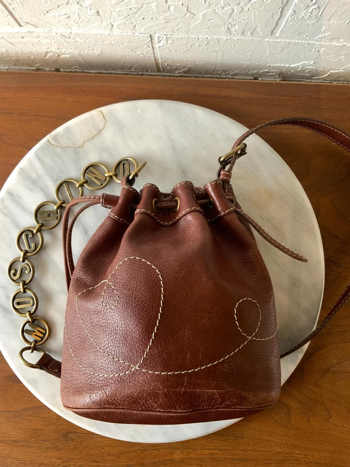 NEW in the shop and she won&rsquo;t last long. Vintage 90s Moschino brown leather bucket bag. Did you see the strap? Fabulous! We love the M O S C H I N O lettering! It is the perfect size for everyday, evening, and travel.

This cutie has a bit of w