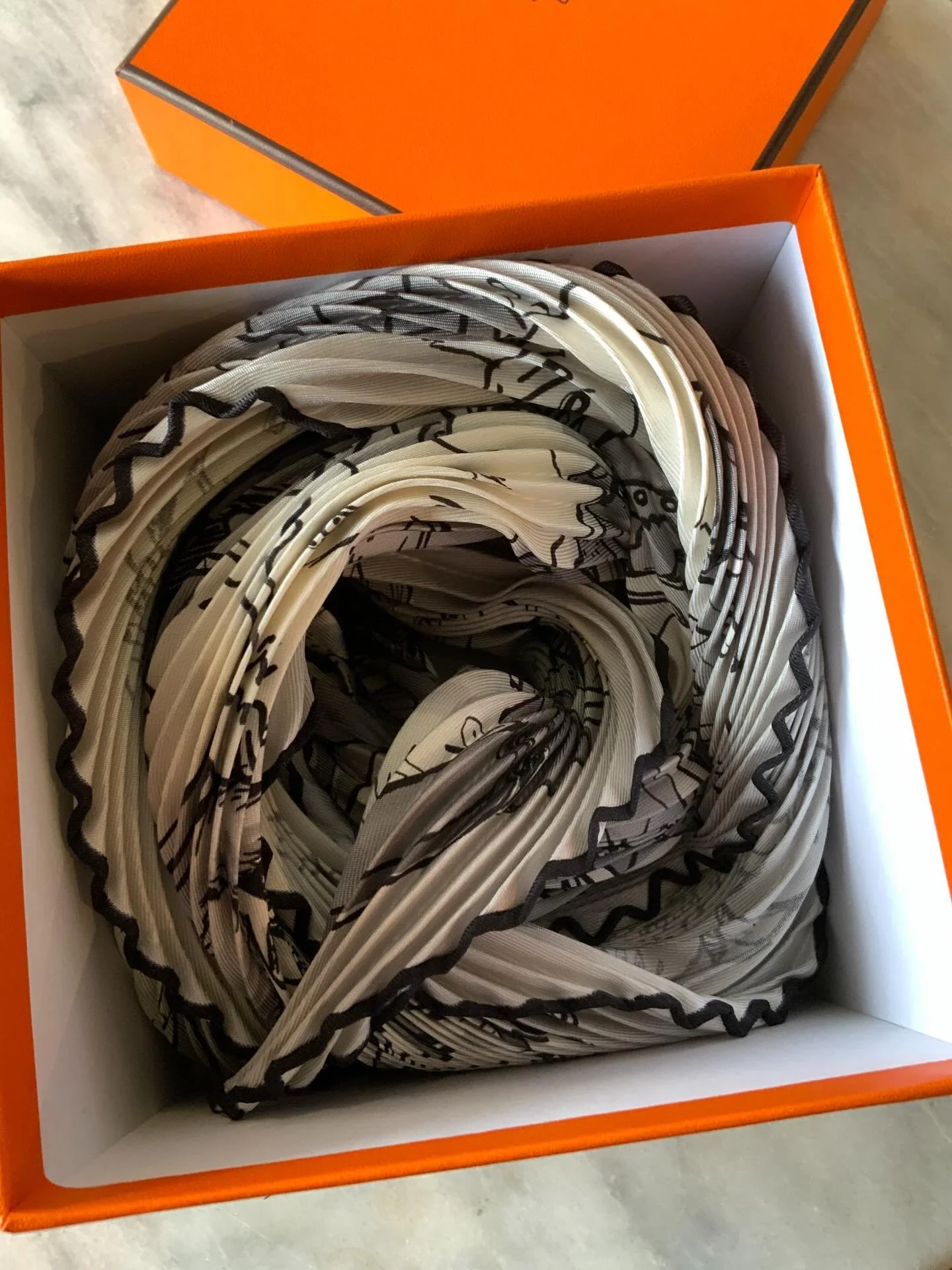 Just arrived, fresh in a crisp orange box&hellip;you know the one. This pliss&eacute; has a kitschy, bold print in a minimalist colour palette, which is a fab combination. This is the &ldquo;Metamorphoses&rdquo;, which we think is great for this time