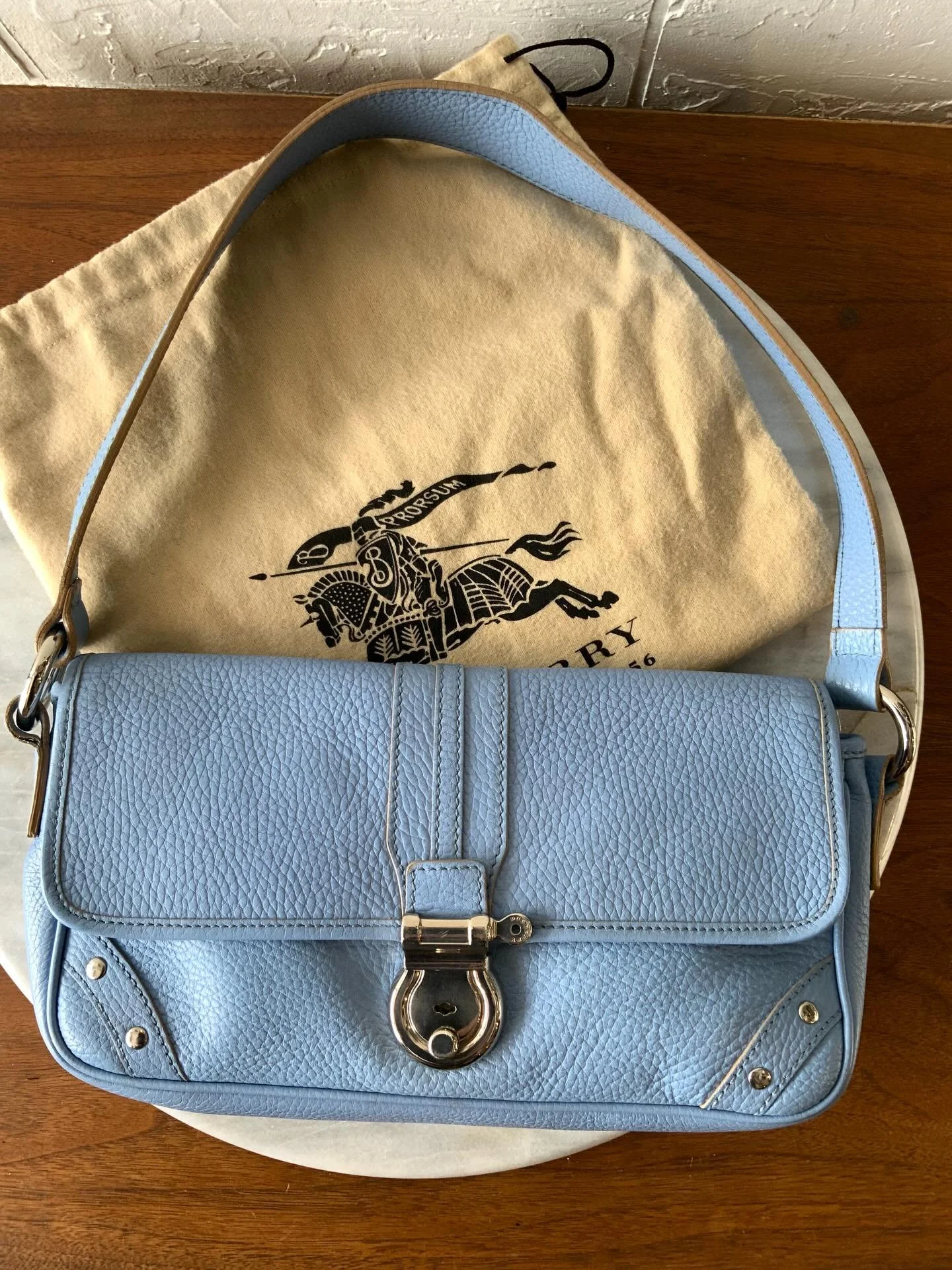 New &amp; Adorable: sky blue mini shoulder bag by your fav. classic British designer ( spot that nova check lining). Made with a gorgeous pebbled leather, features silver hardware, and has a push lock closure.

The perfect size for day and night. Fit