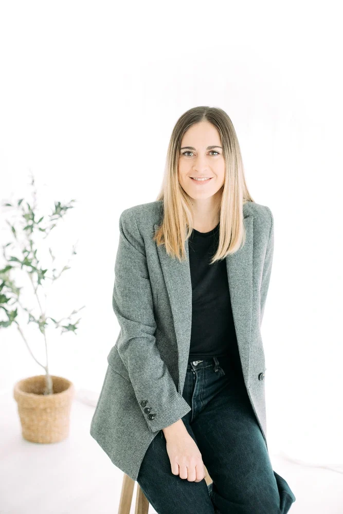 jade mac sweeney, coaching individuel de sens, jeune femme blonde souriante, blazer gris, assise sur un tabouret