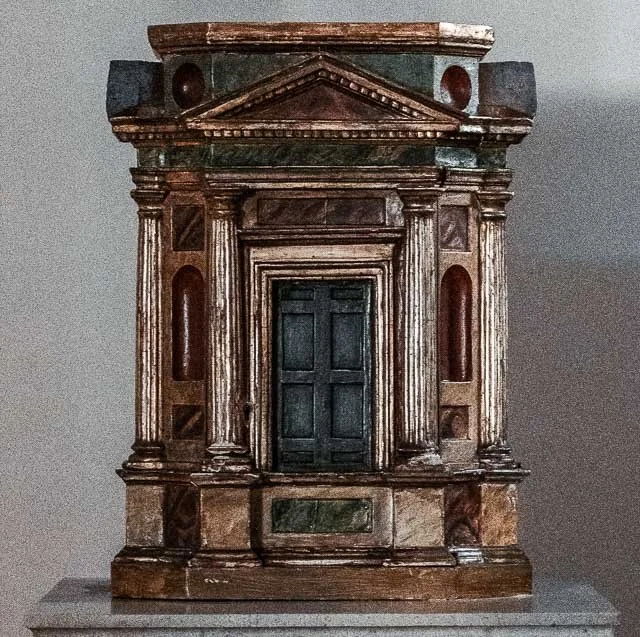 An intricate antique wooden cabinet with columns and decorative details.