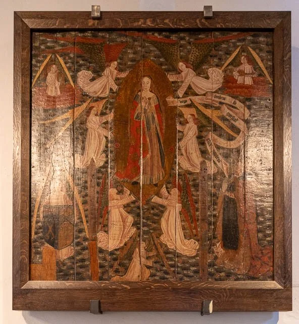 Painting depicts the Virgin Mary surrounded by angels, with musical instruments in the background, framed in wood.