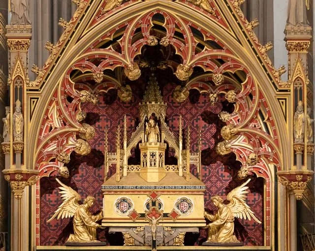 Ornate church altar with gold statues of angels, religious figures, and intricate architectural details.