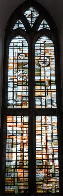 Colorful stained glass window with geometric patterns and circular designs.