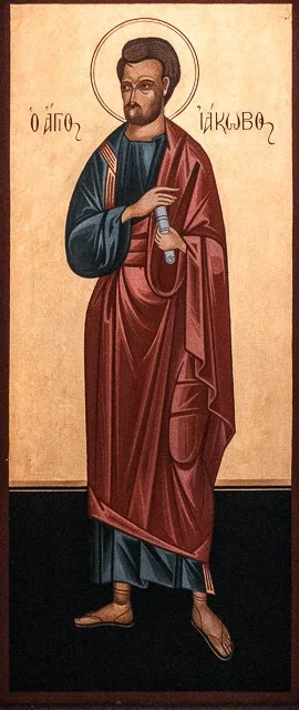 A religious icon painting of a male saint, dressed in traditional robes, standing against a plain background. He has a halo around his head, and Greek script is written beside him.